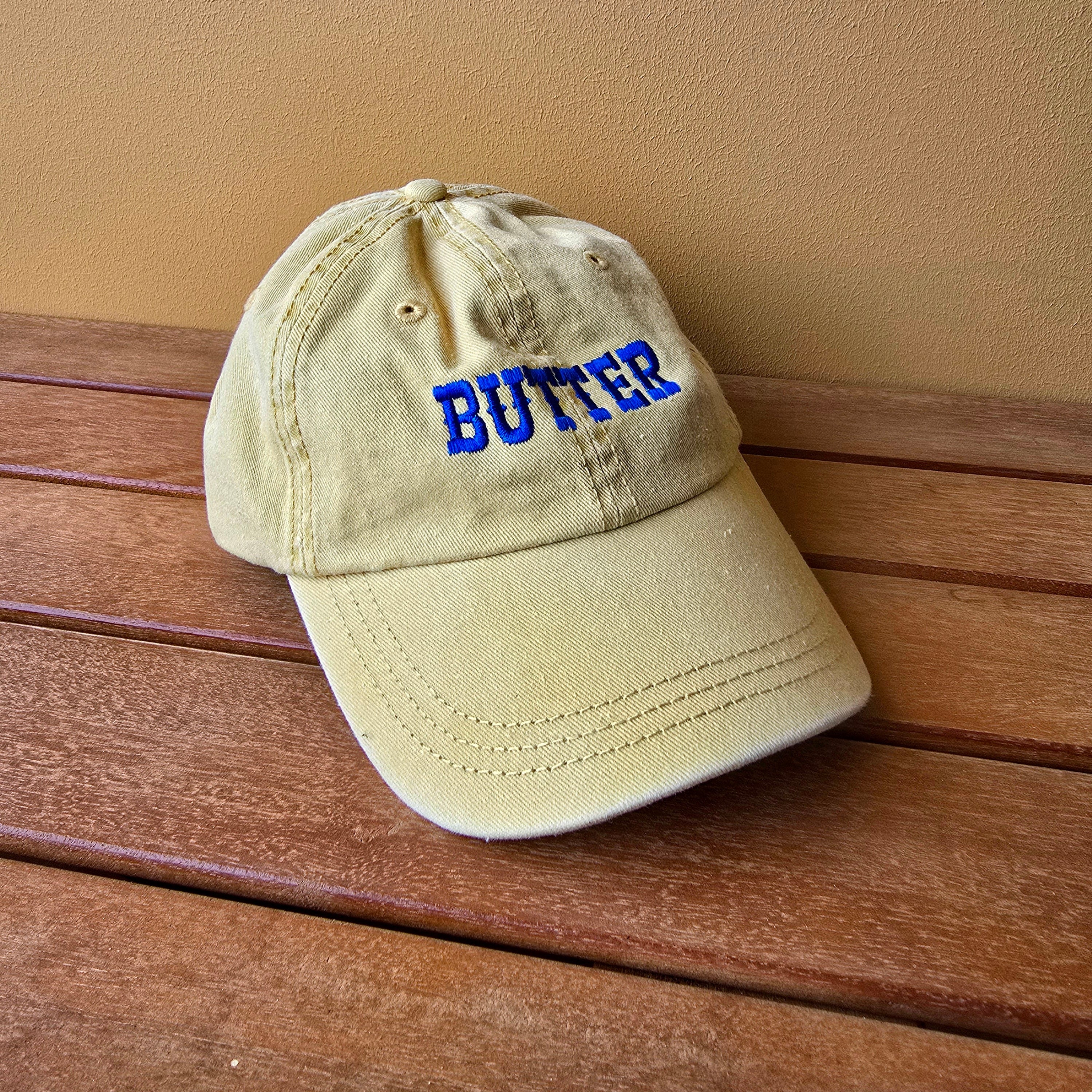 Beige cap with blue text on a wooden surface