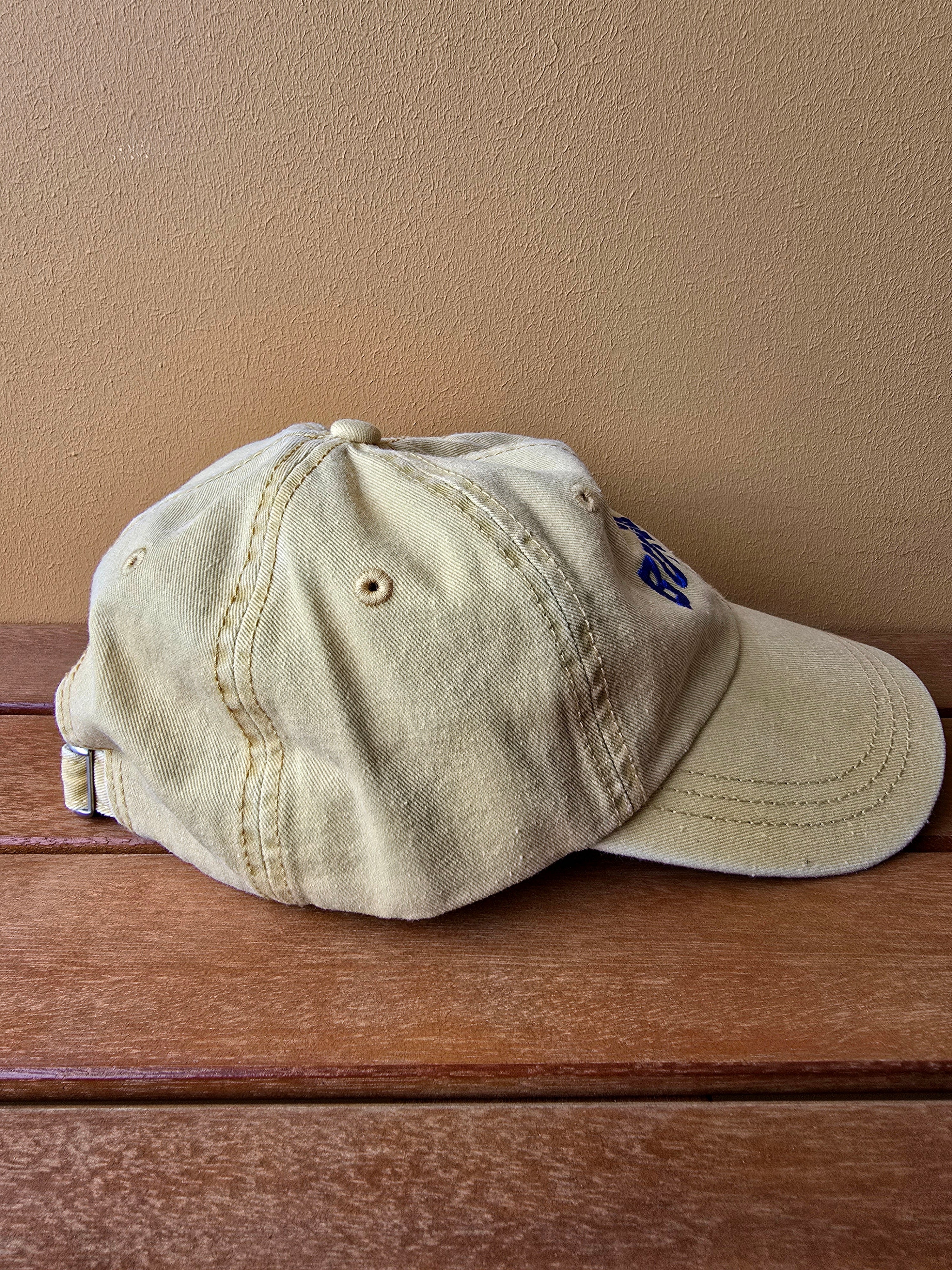 washed yellow cap with a logo on a wooden surface