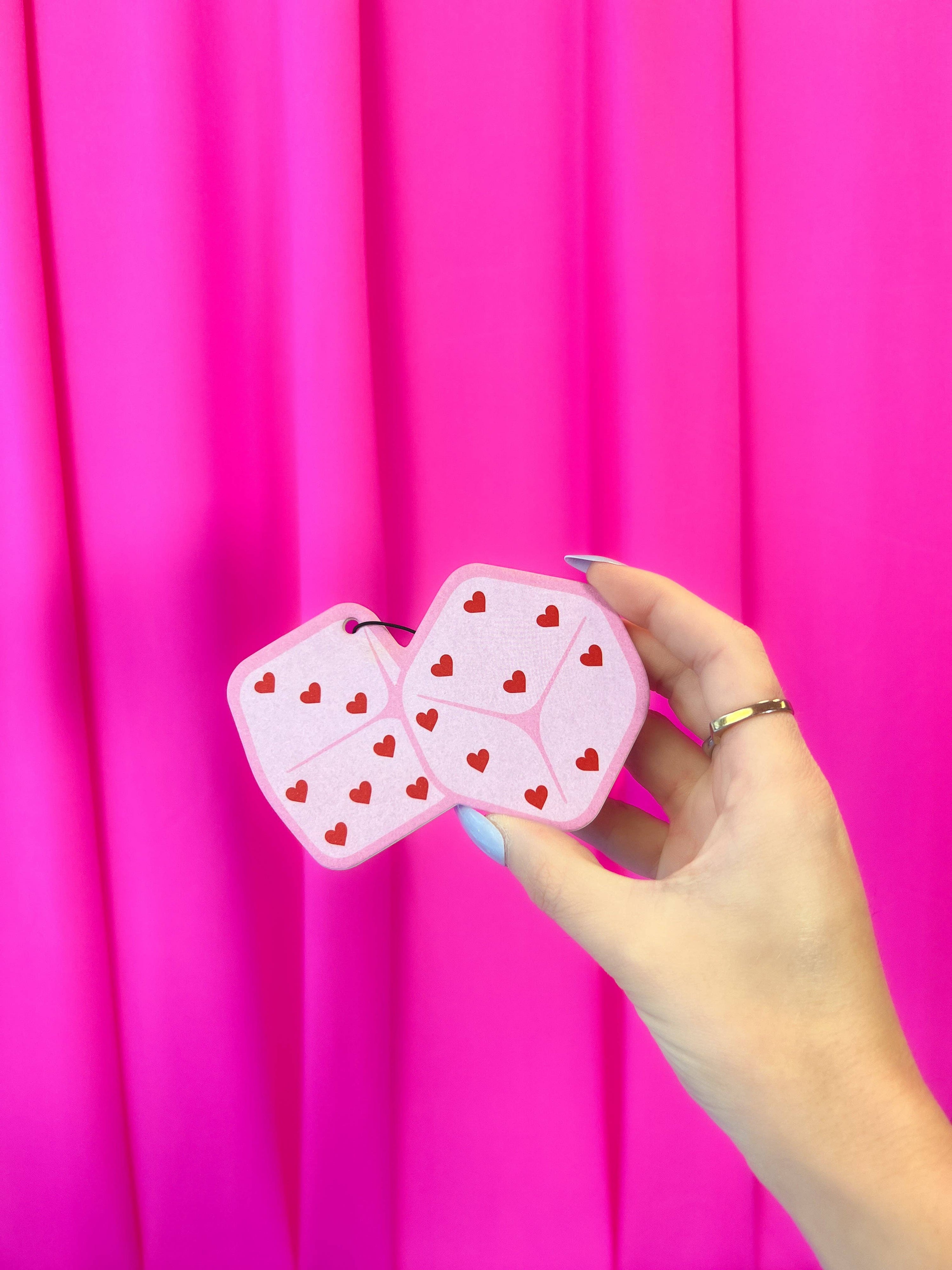 Pink Heart Dice Air Freshener held by a hand