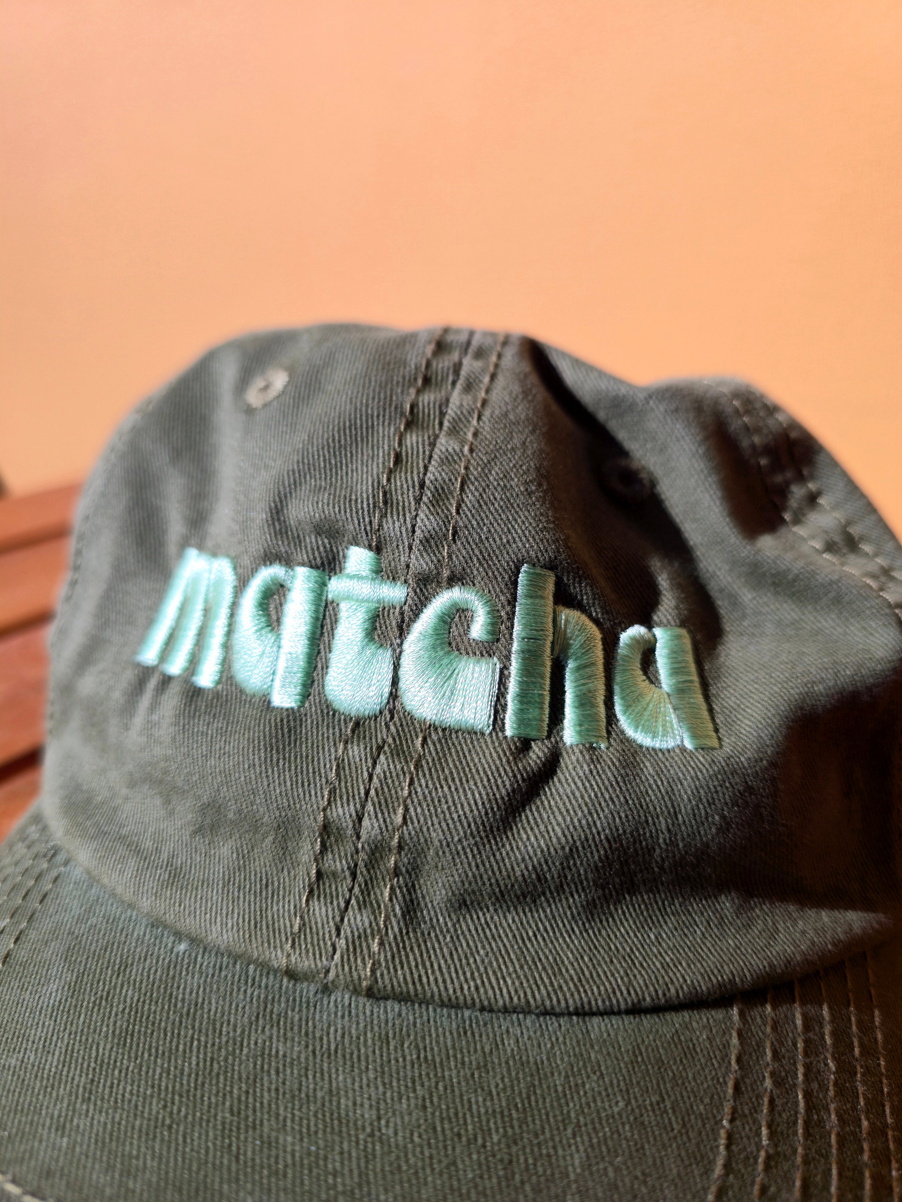 Close-up of a cap with 'matches' branding on a beige background