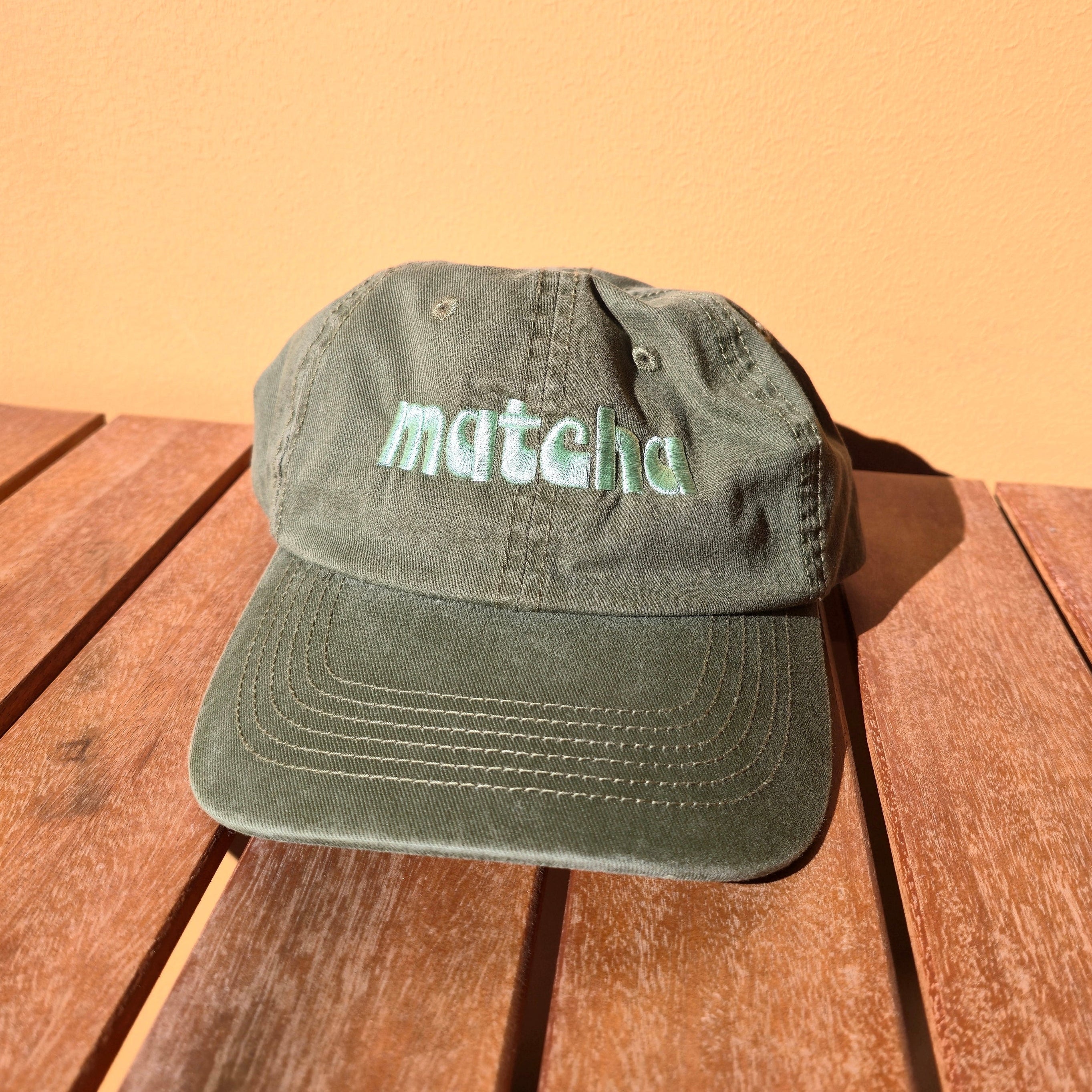 Green cap with 'matcha' text on a wooden surface