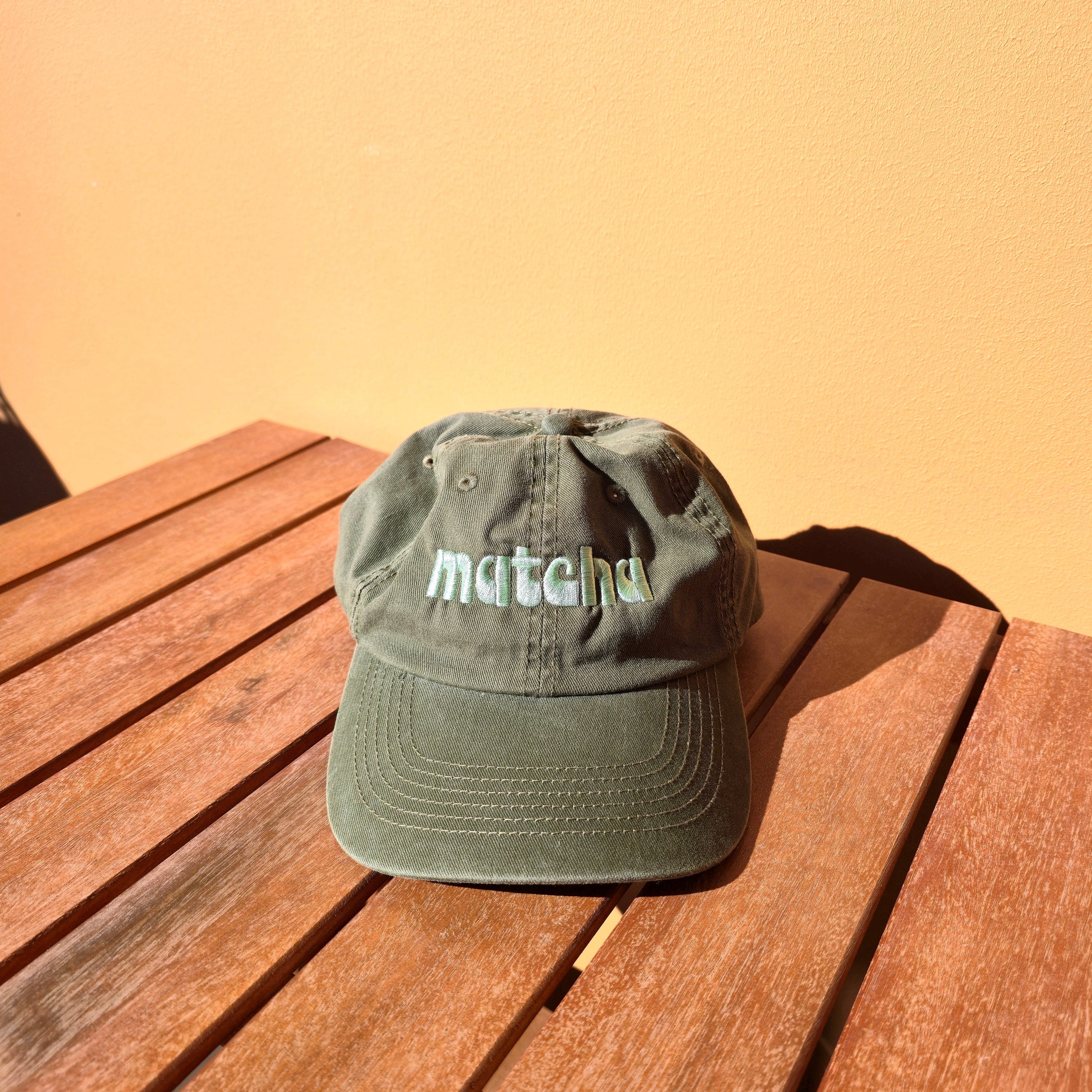 Green cap with text on a wooden surface and beige background