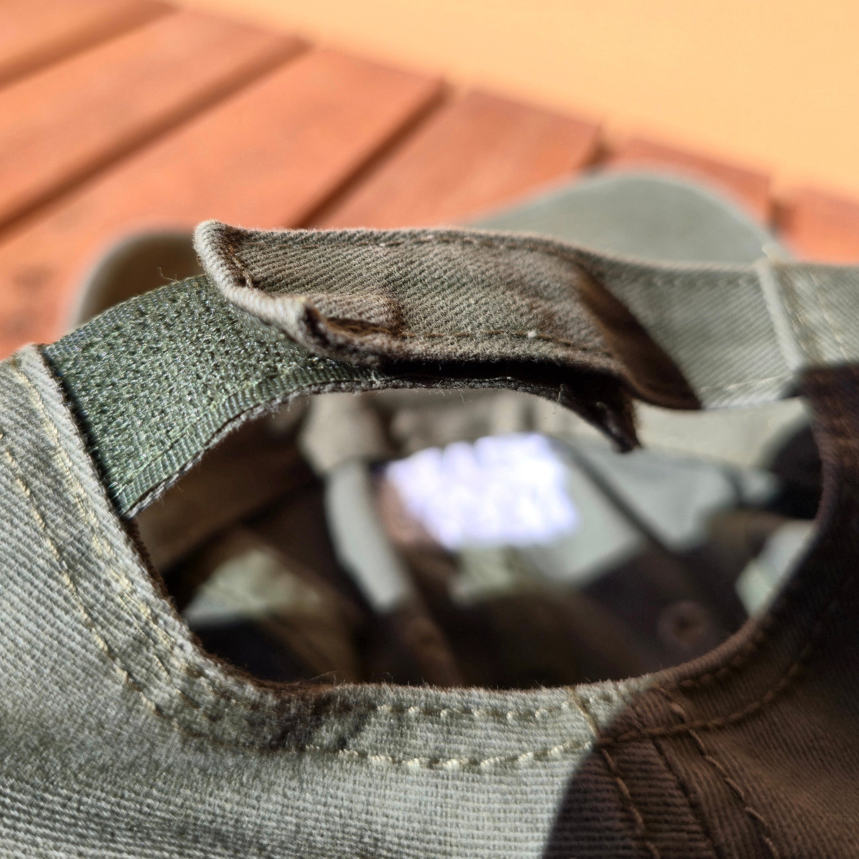 Close-up of a green cap with a brand logo on a blurred background