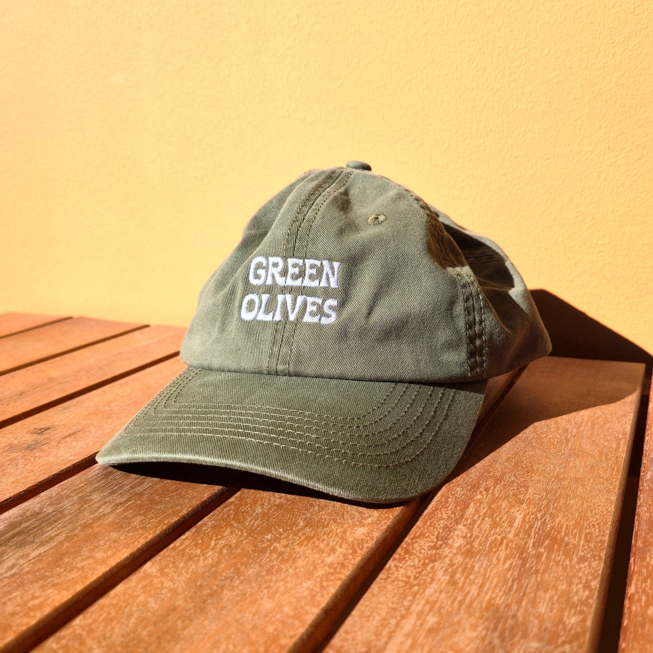 Green cap with text on a wooden surface and yellow background