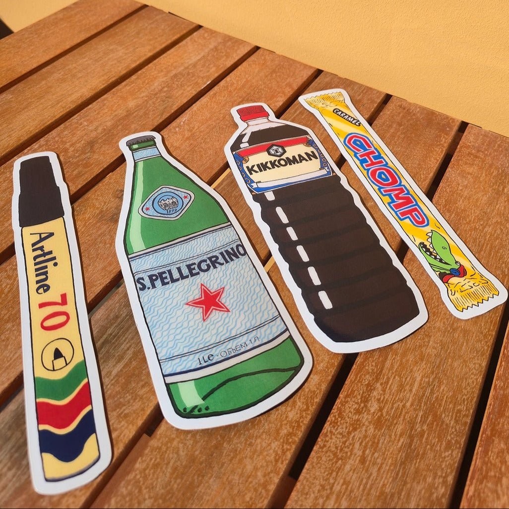 Set of four bottle-shaped magnets on a wooden surface