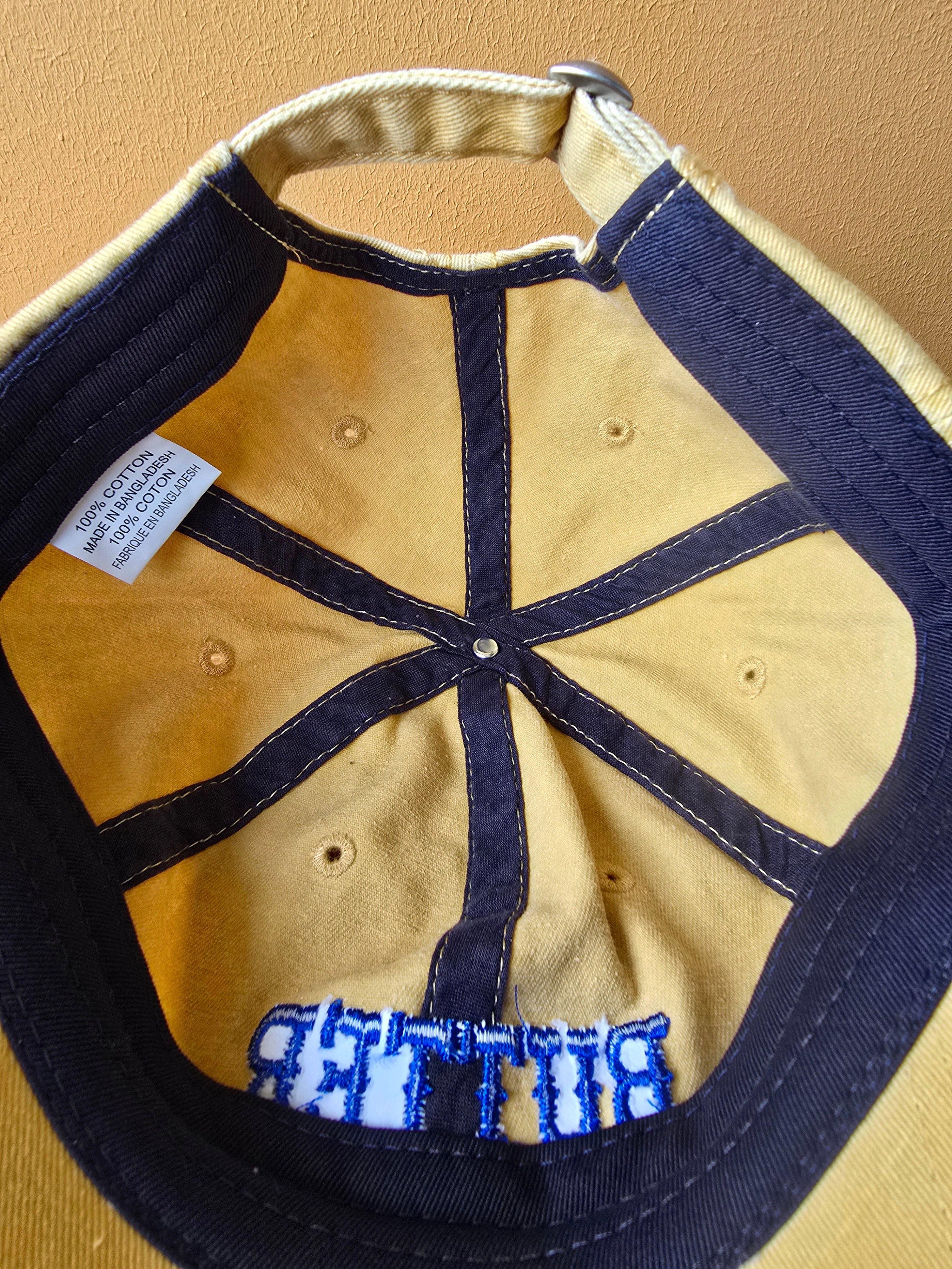 Beige and navy cap with 'Blue' branding on a beige background