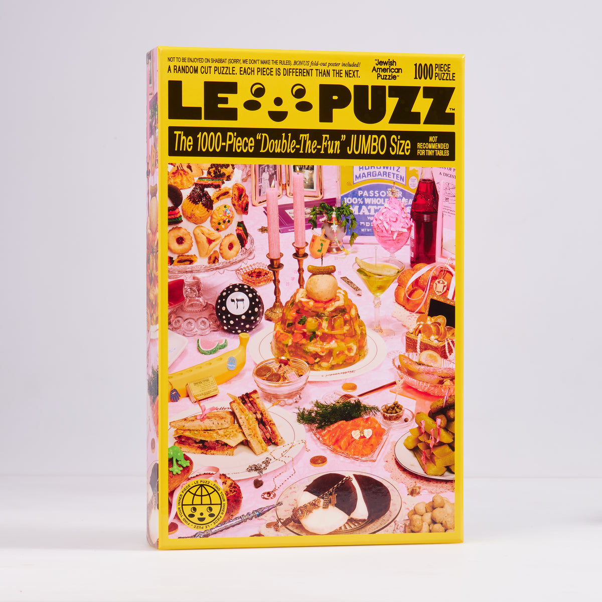 Le Puzz Jewish American Puzzle 1000-piece box featuring food, pink candles and keepsakes on a pink table.