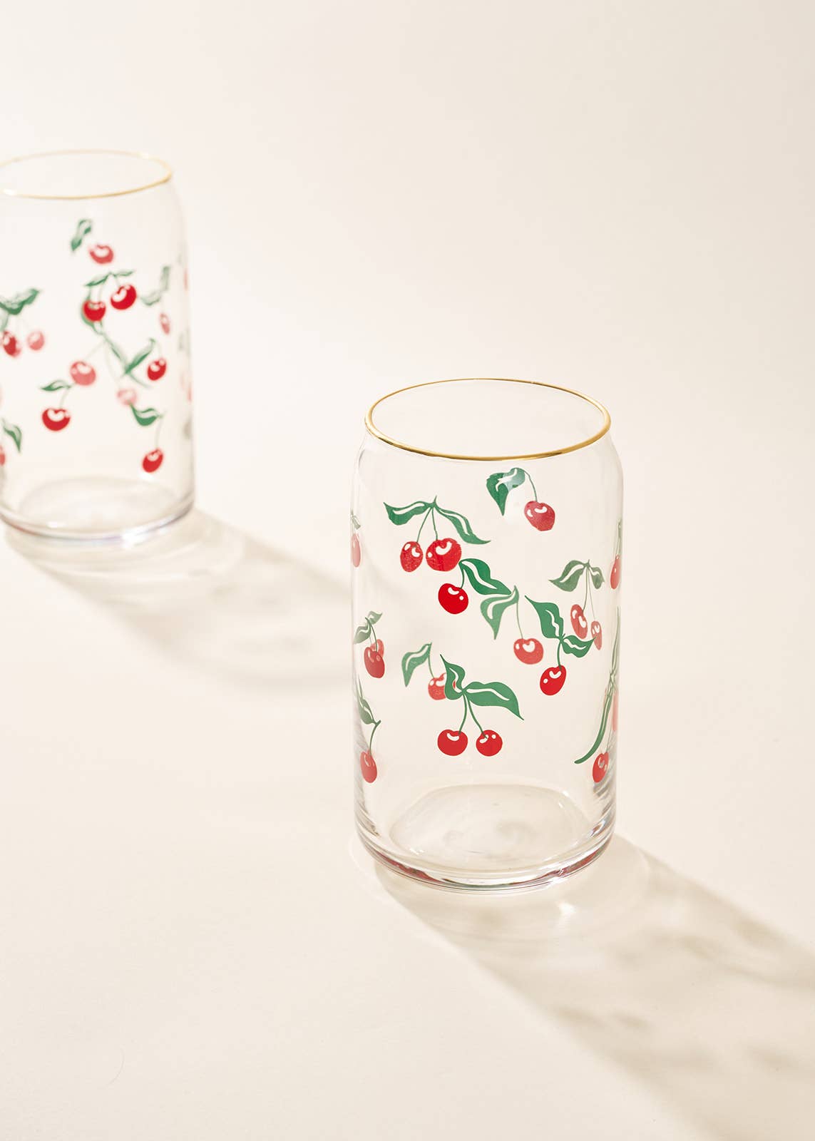 Clear glass tumblers with cherry design on a light background