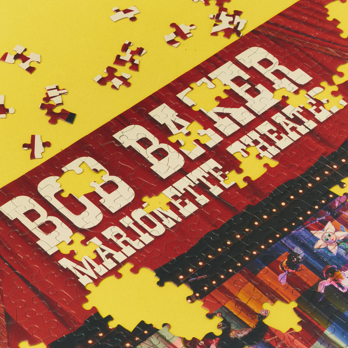 Partially assembled On a Heartstring puzzle showing the Bob Baker Marionette Theater name on red curtains.