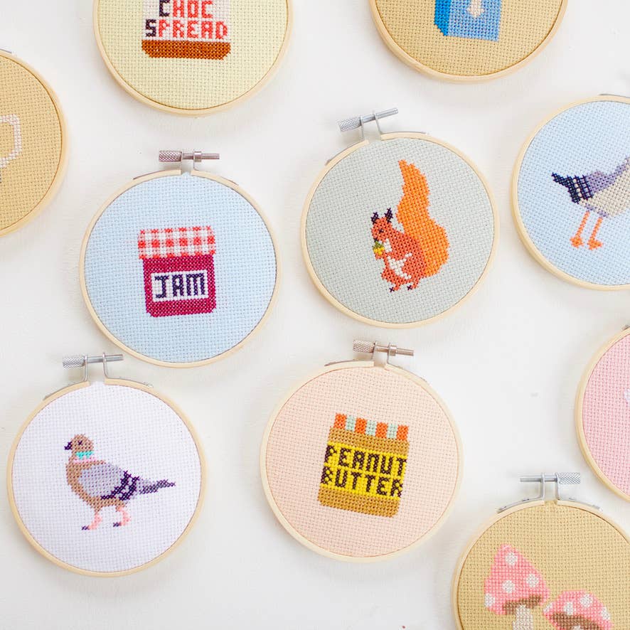Collection of cross-stitched pieces in various hoops on a white background