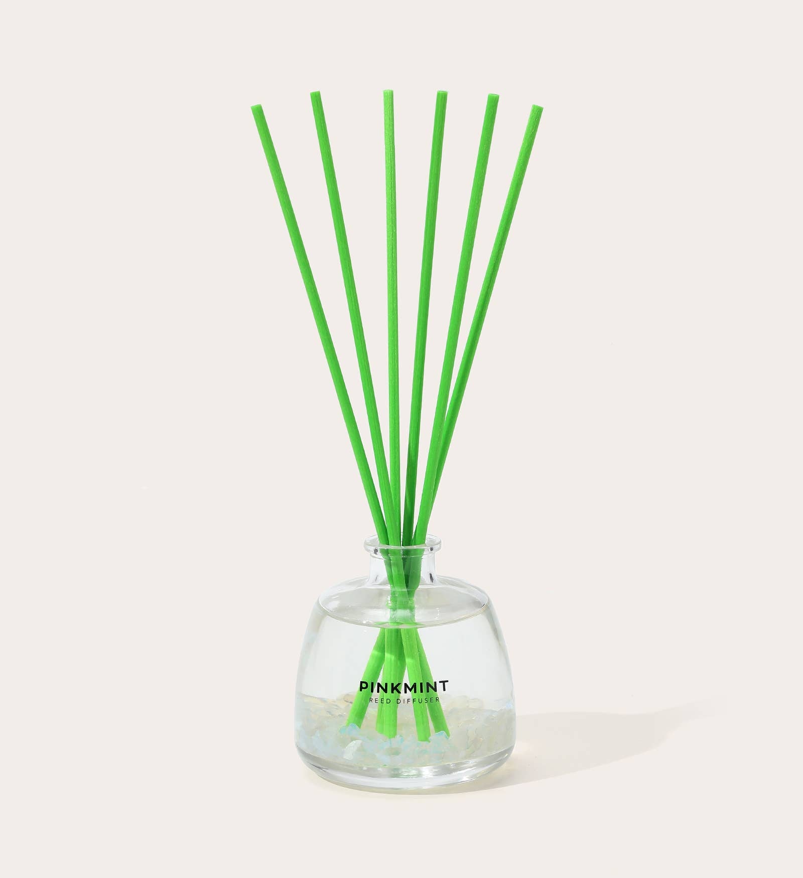 Clear glass diffuser with green sticks labeled 'Pink Mint' on a white background