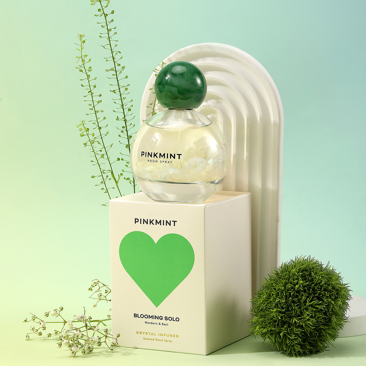 Pinkmint perfume bottle with green cap on a light green background