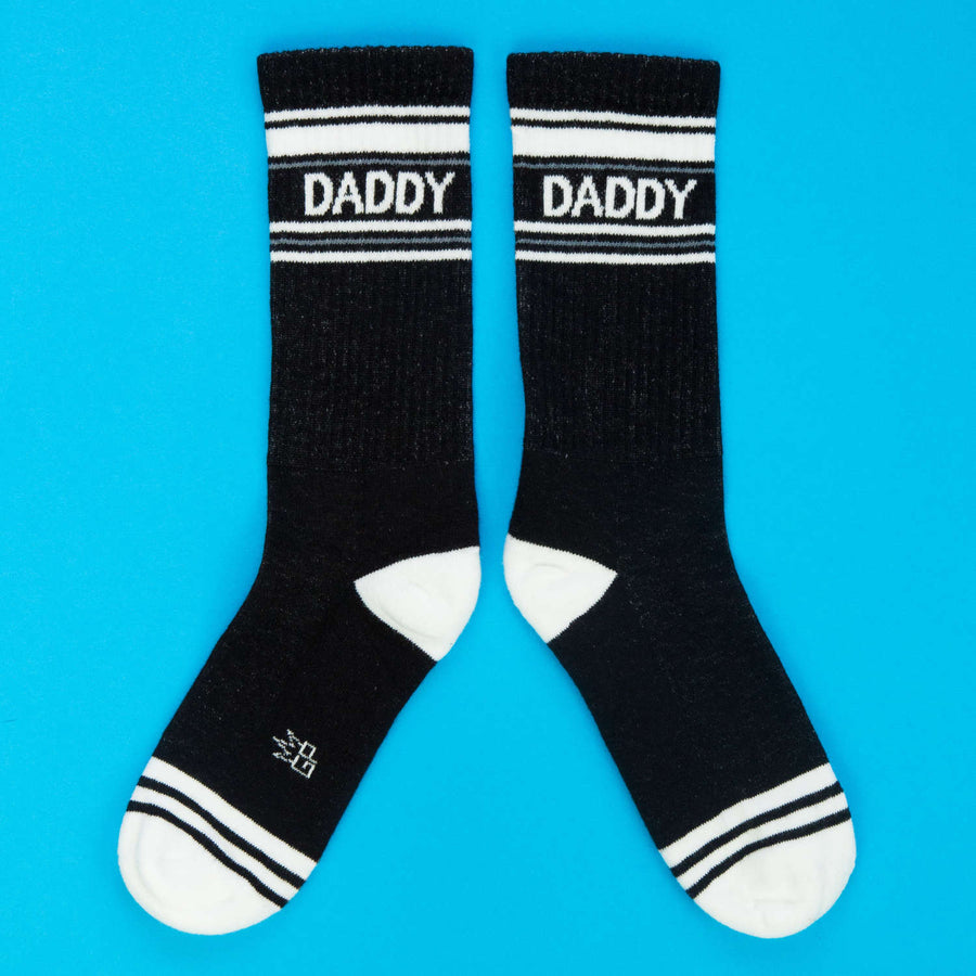 Black socks with 'DADDY' text on a blue background