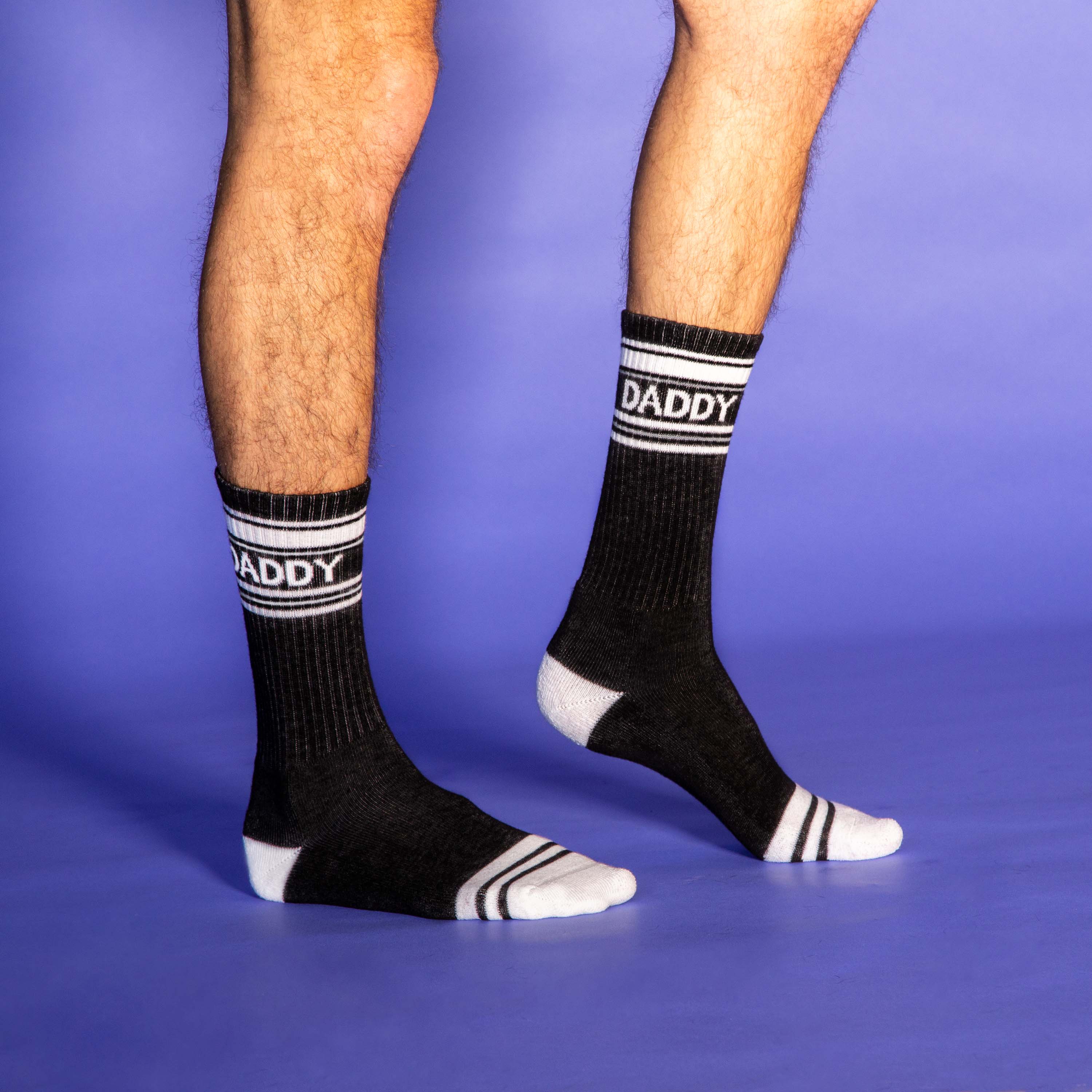 Black socks with 'DADDY' text on a purple background