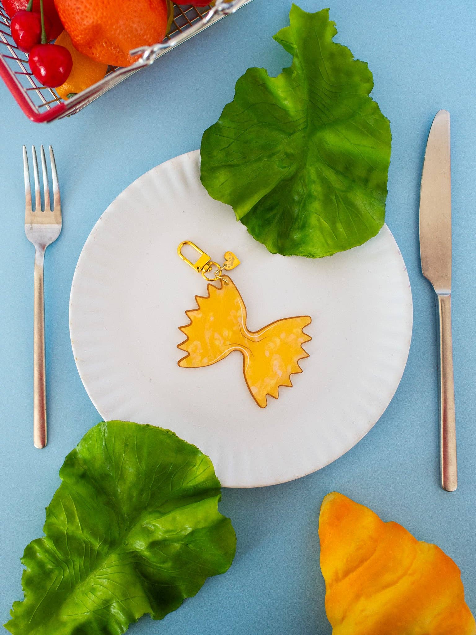 Farfalle Pasta Keychain on white plate with blue table