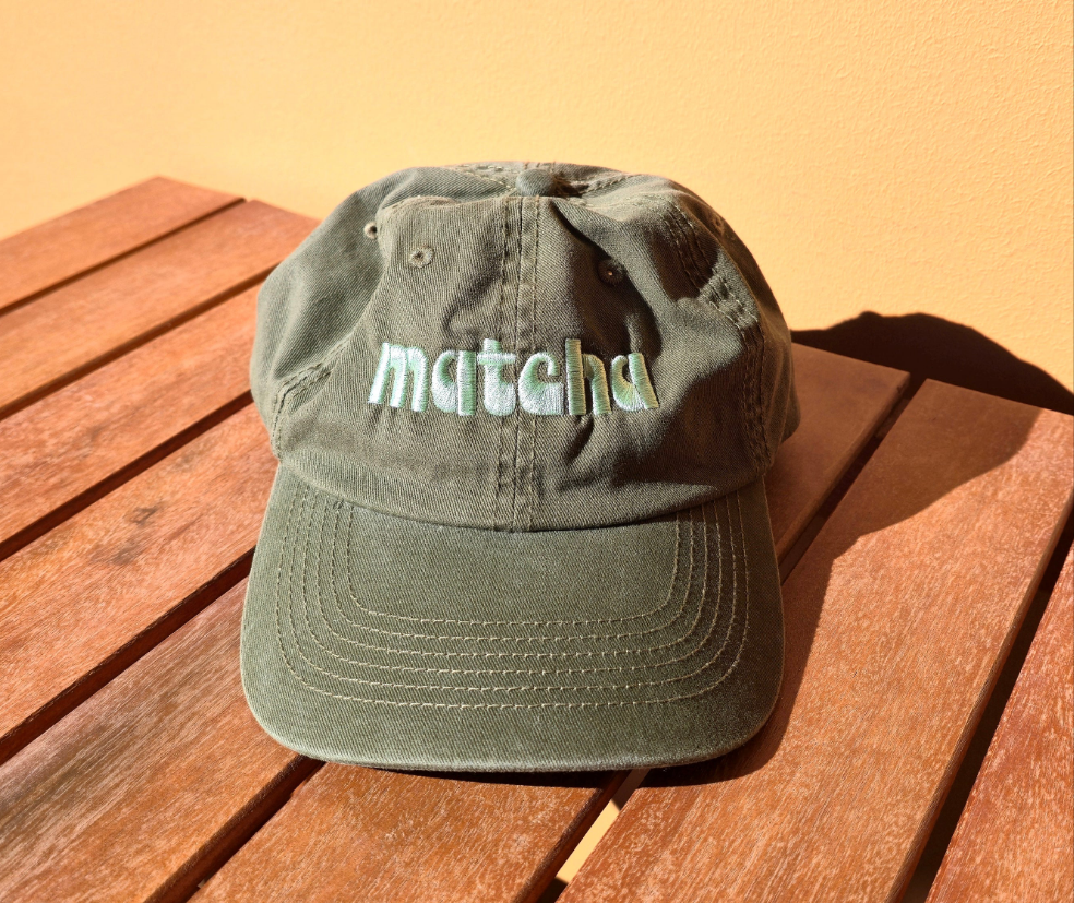 Green cap with 'matcha' text on a wooden surface