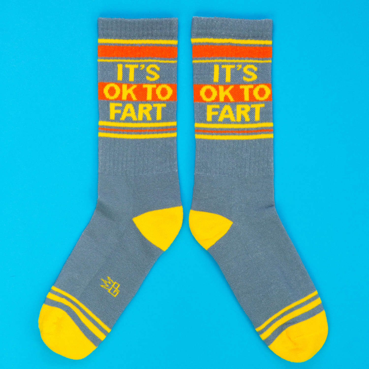 Gray socks with 'It's Ok to Fart' text on a blue background