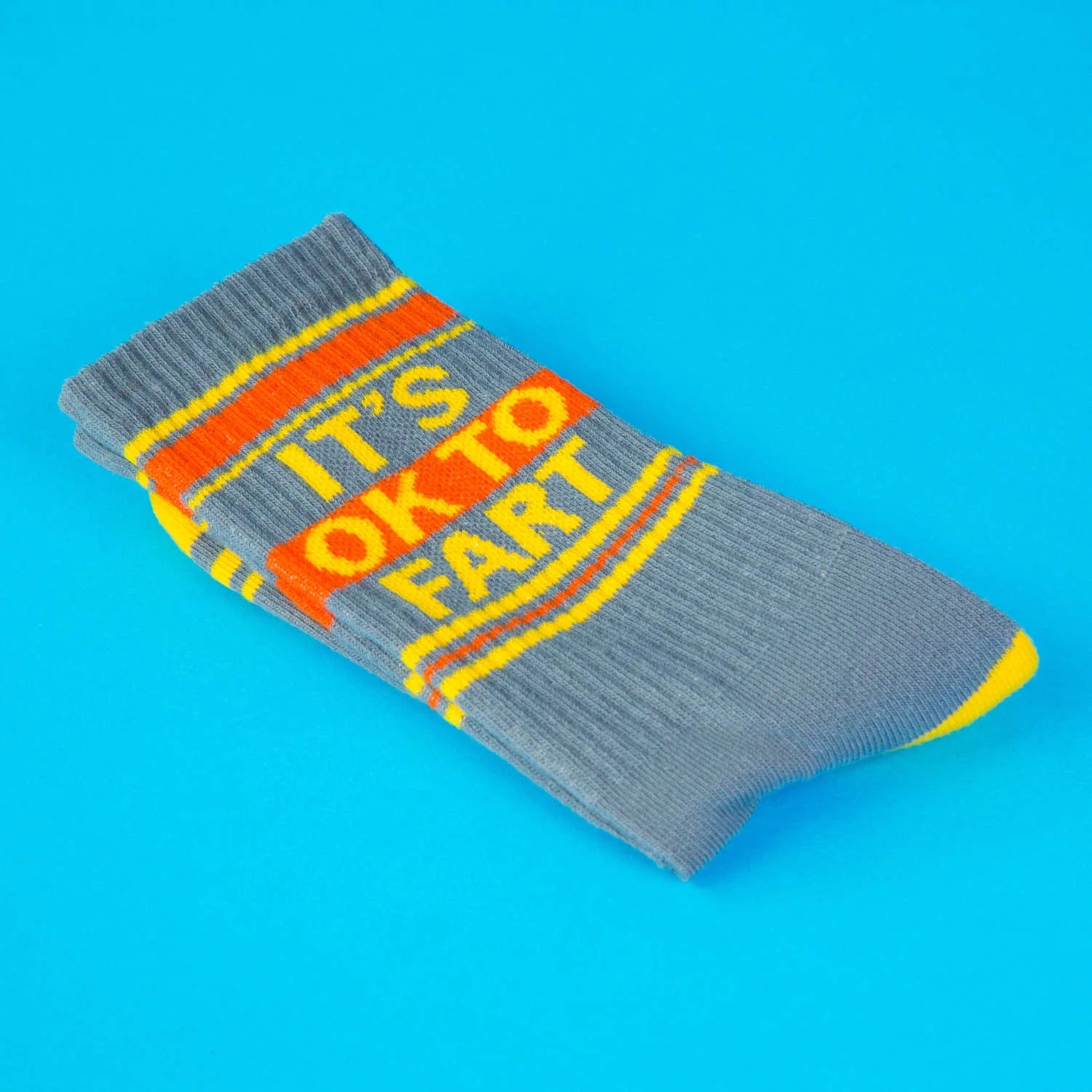 Gray sock with orange and yellow text on a blue background