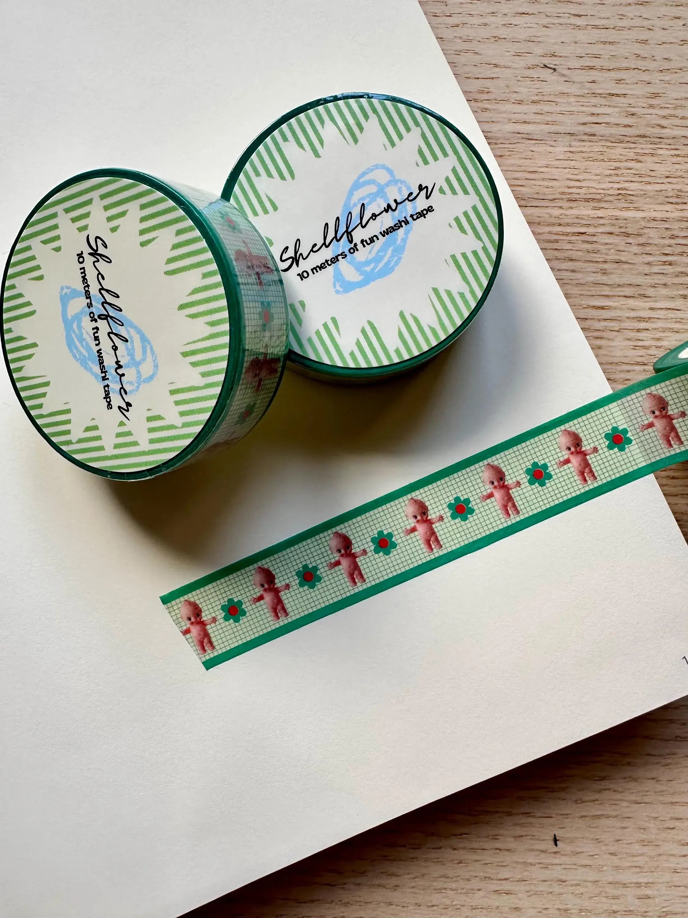 Two rolls of washi tape with a decorative strip on a white surface