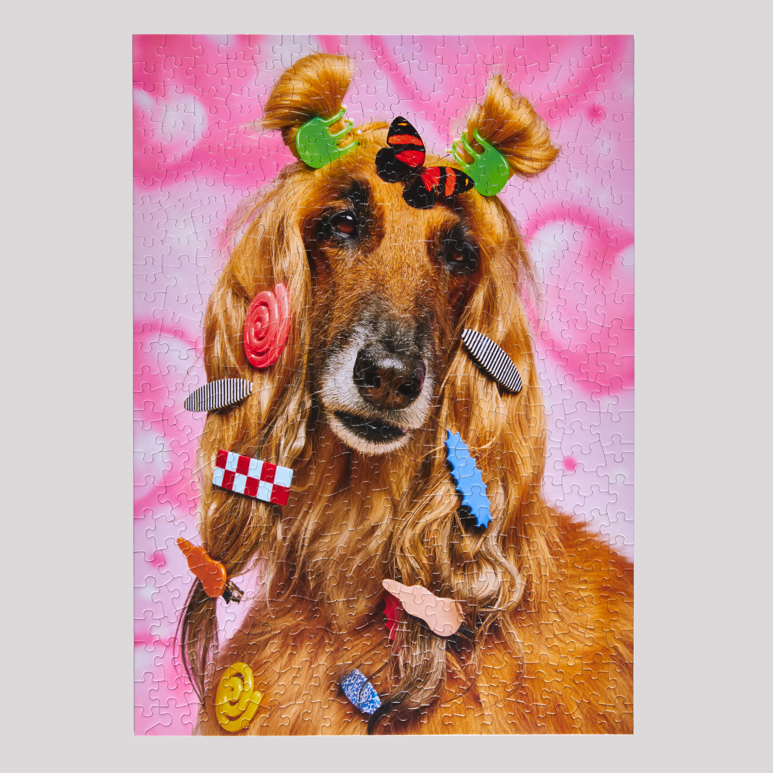Jigsaw puzzle with a dog wearing colorful hair accessories on a pink background