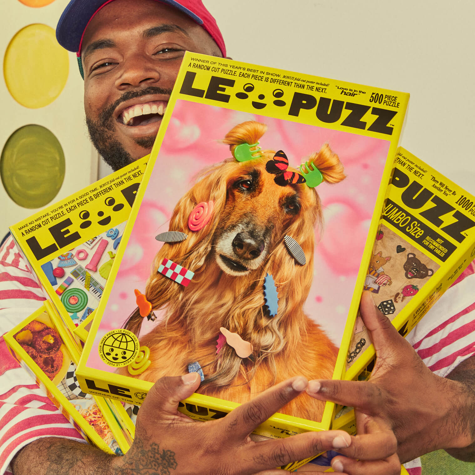Person holding a 'LE PUZZ' puzzle with a dog design on a colorful background