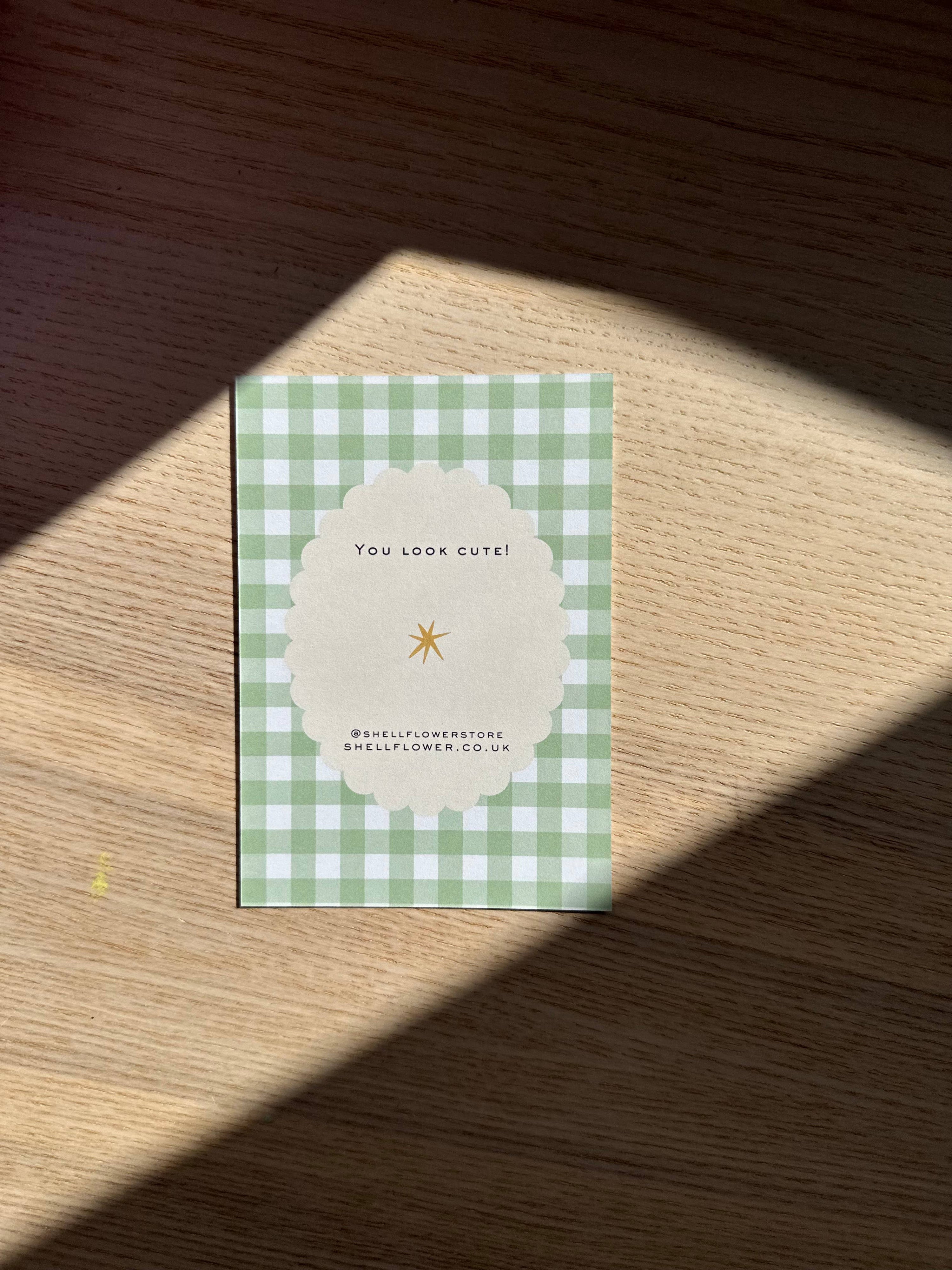 Green checkered card with text on a wooden surface