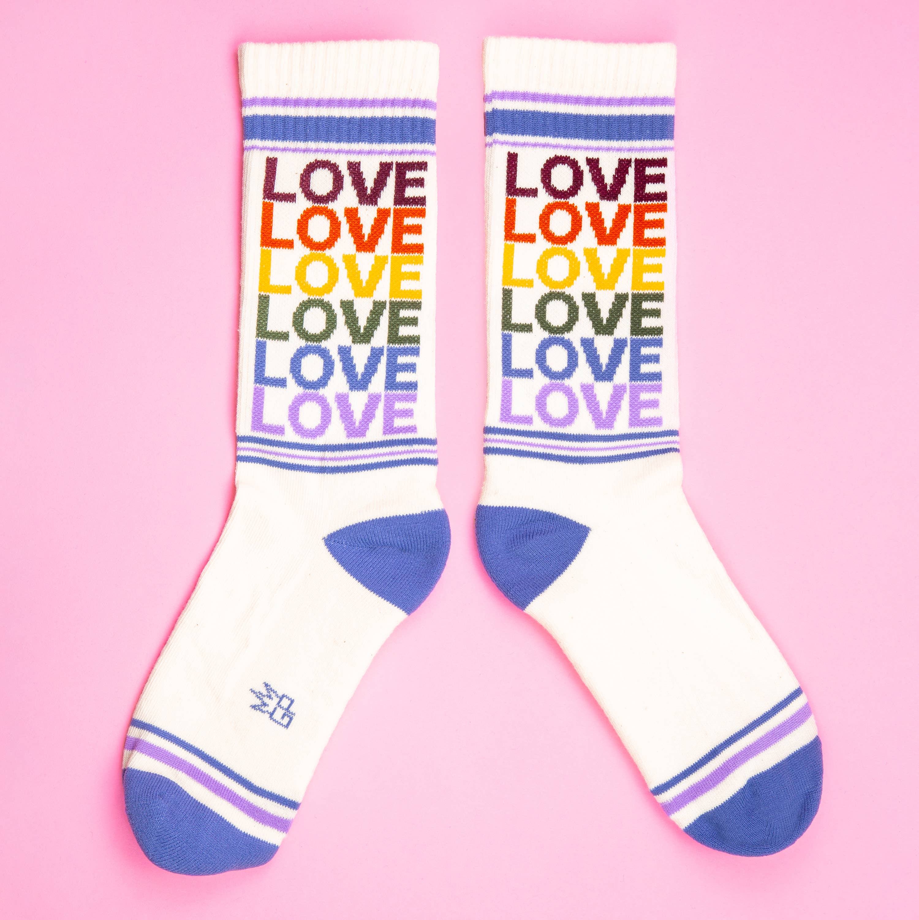 White socks with 'LOVE' in rainbow colors on a pink background