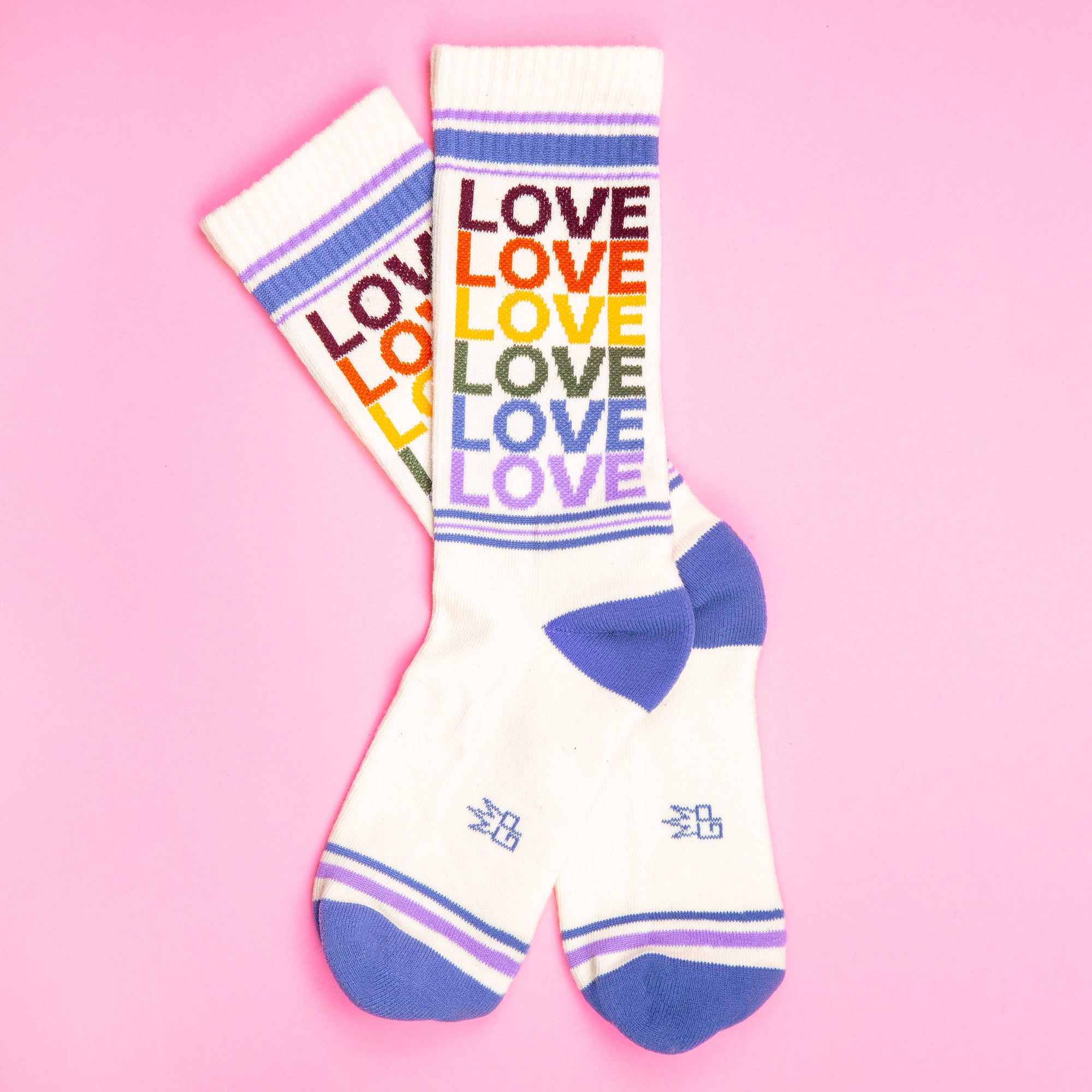 White socks with rainbow 'LOVE' text on a pink background