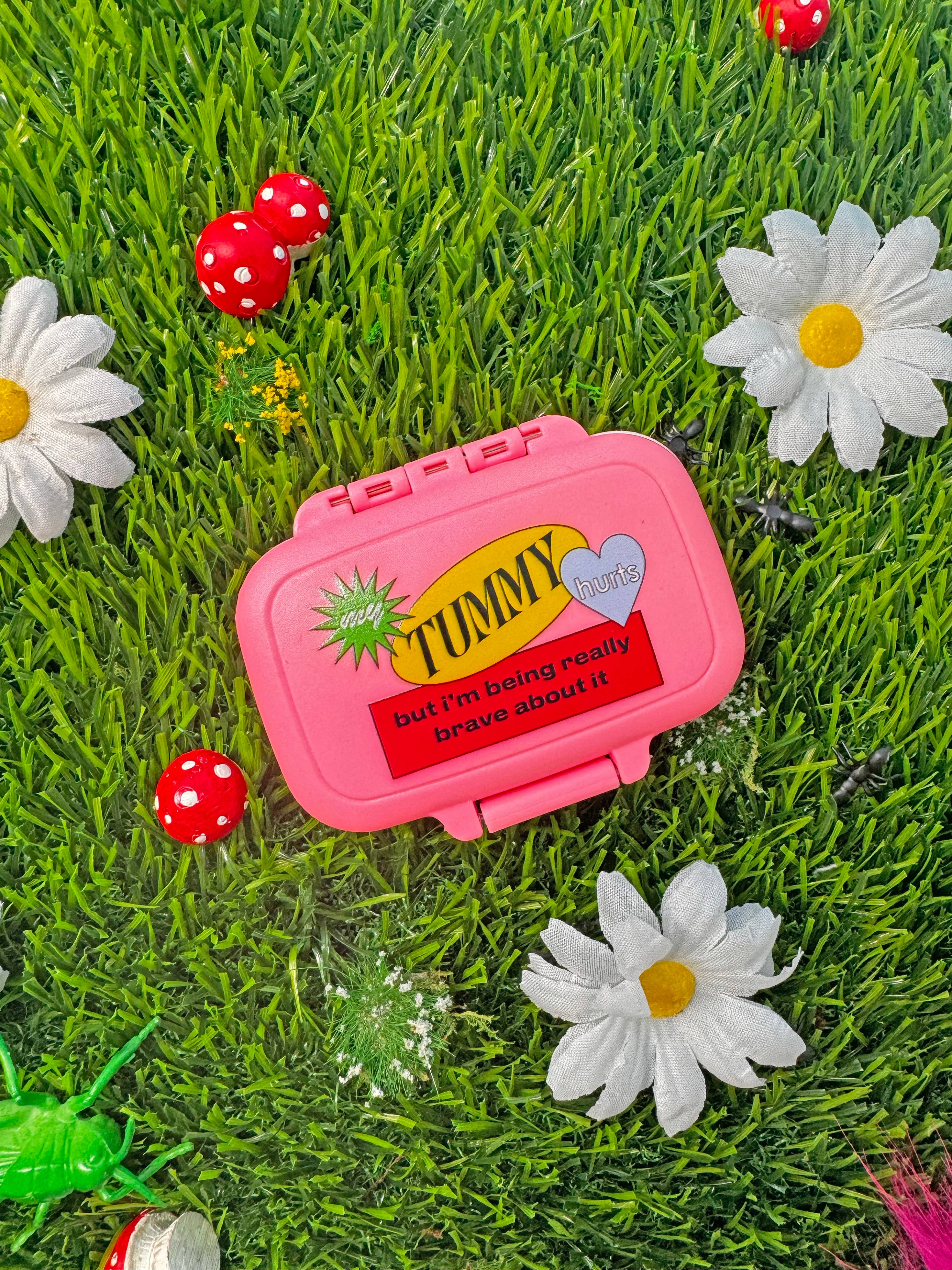 my tummy hurts pink pill case on grass