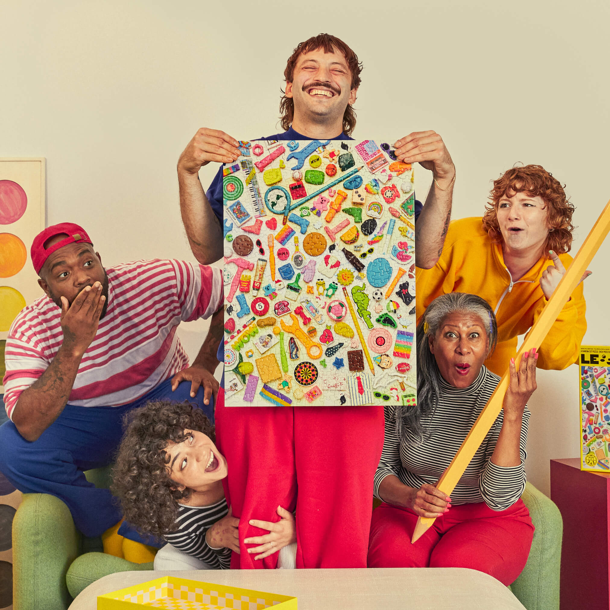 Group of people reacting to a colorful poster held by one person, with a playful and vibrant atmosphere.