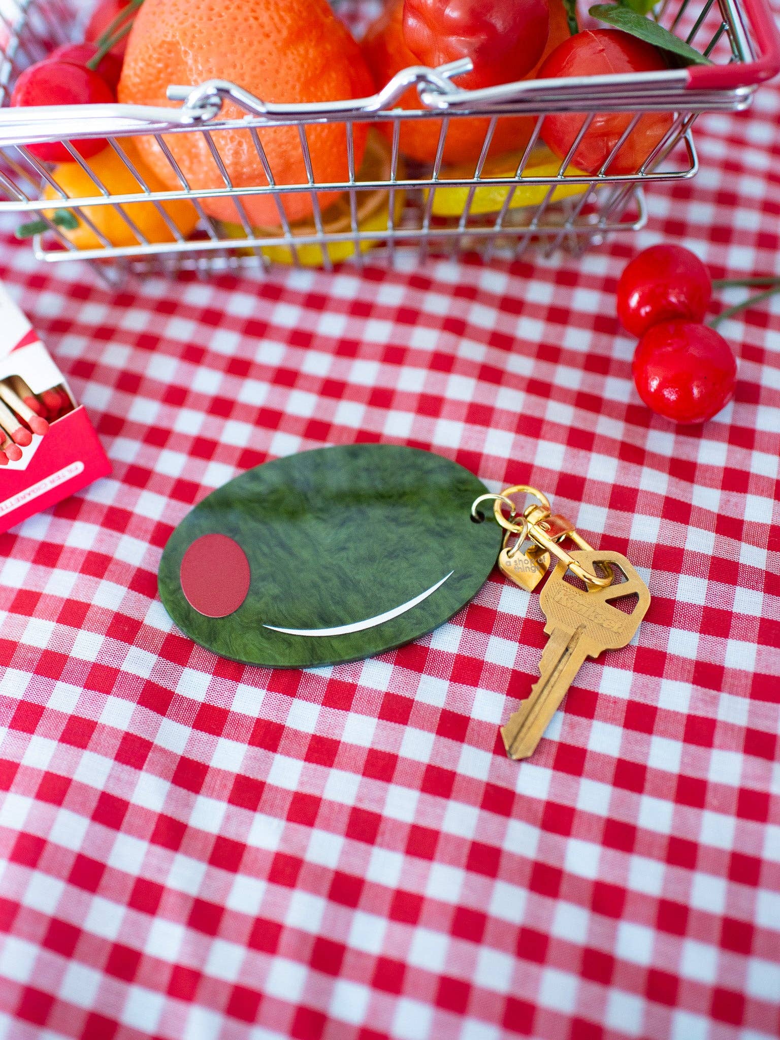 Olive Keychain close up on white and red table