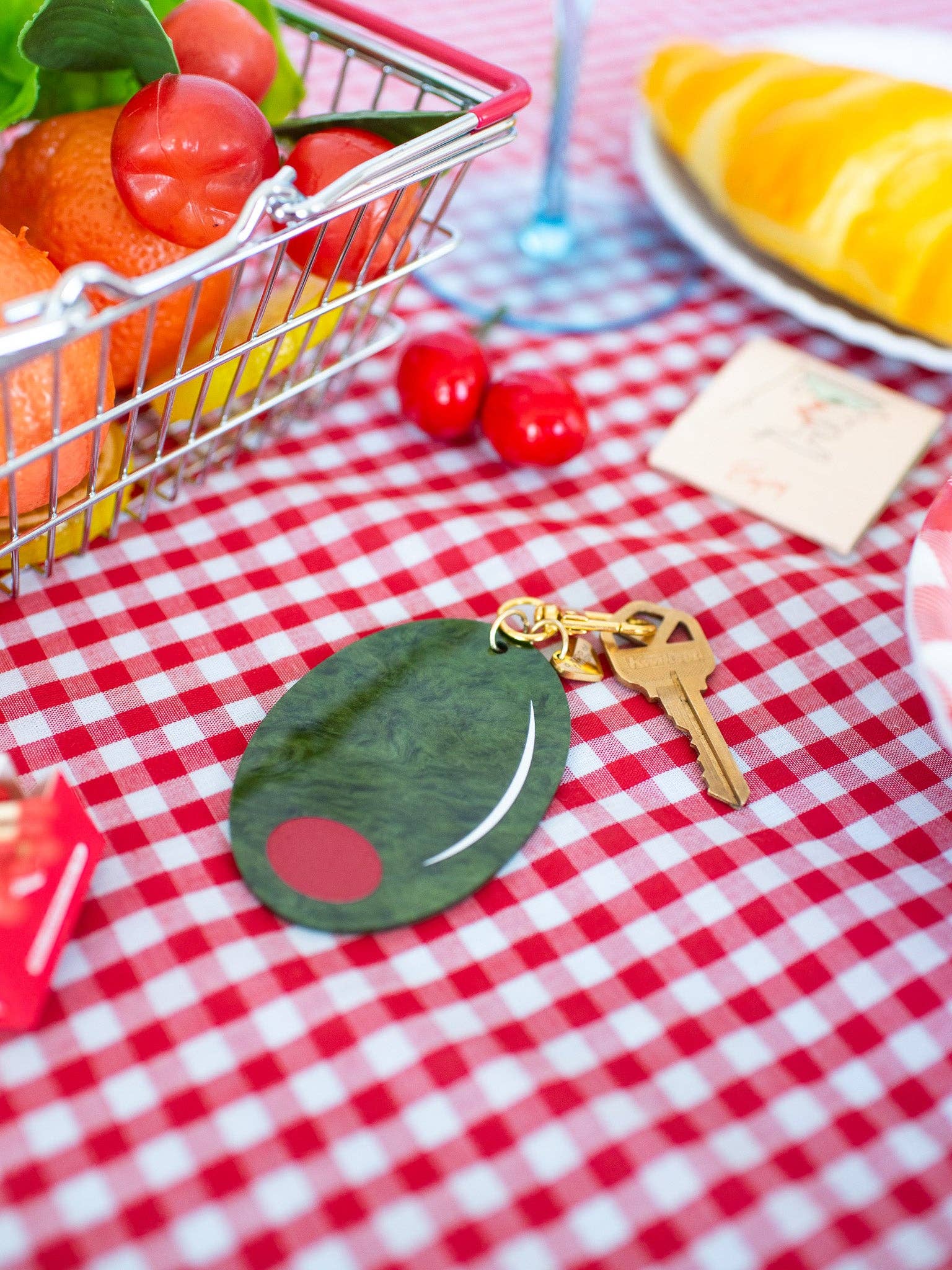 Olive Keychain up close with red and white table cloth