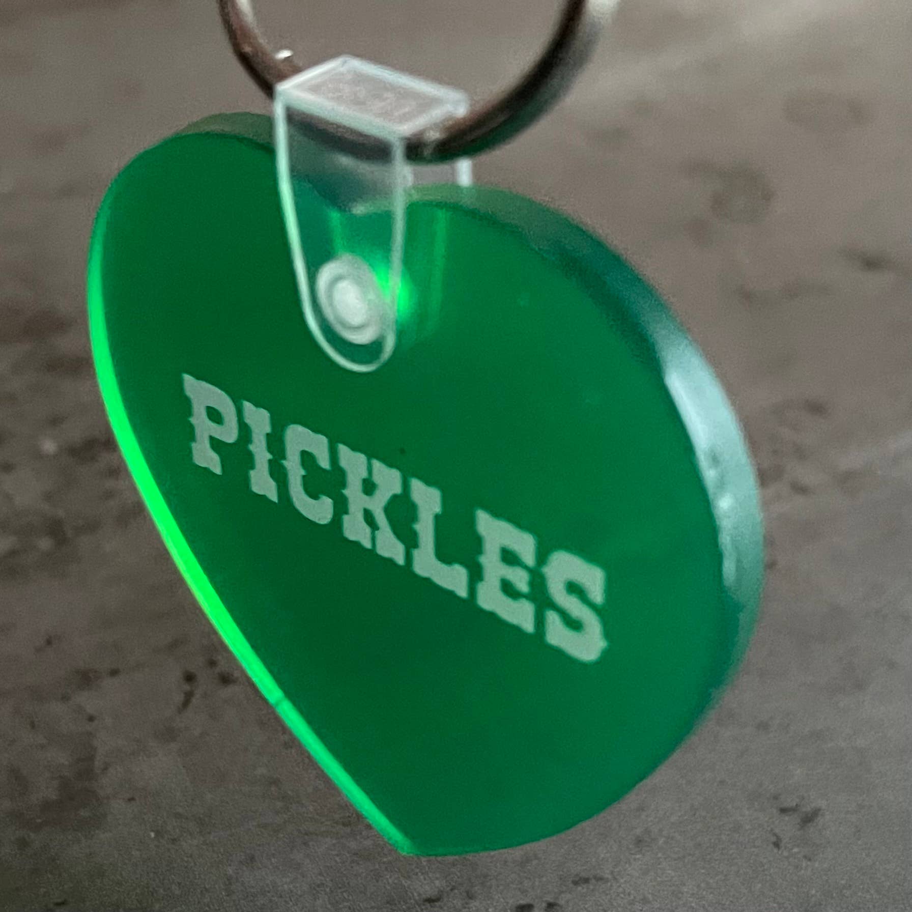 Green heart-shaped tag with 'PICKLES' text on a gray background