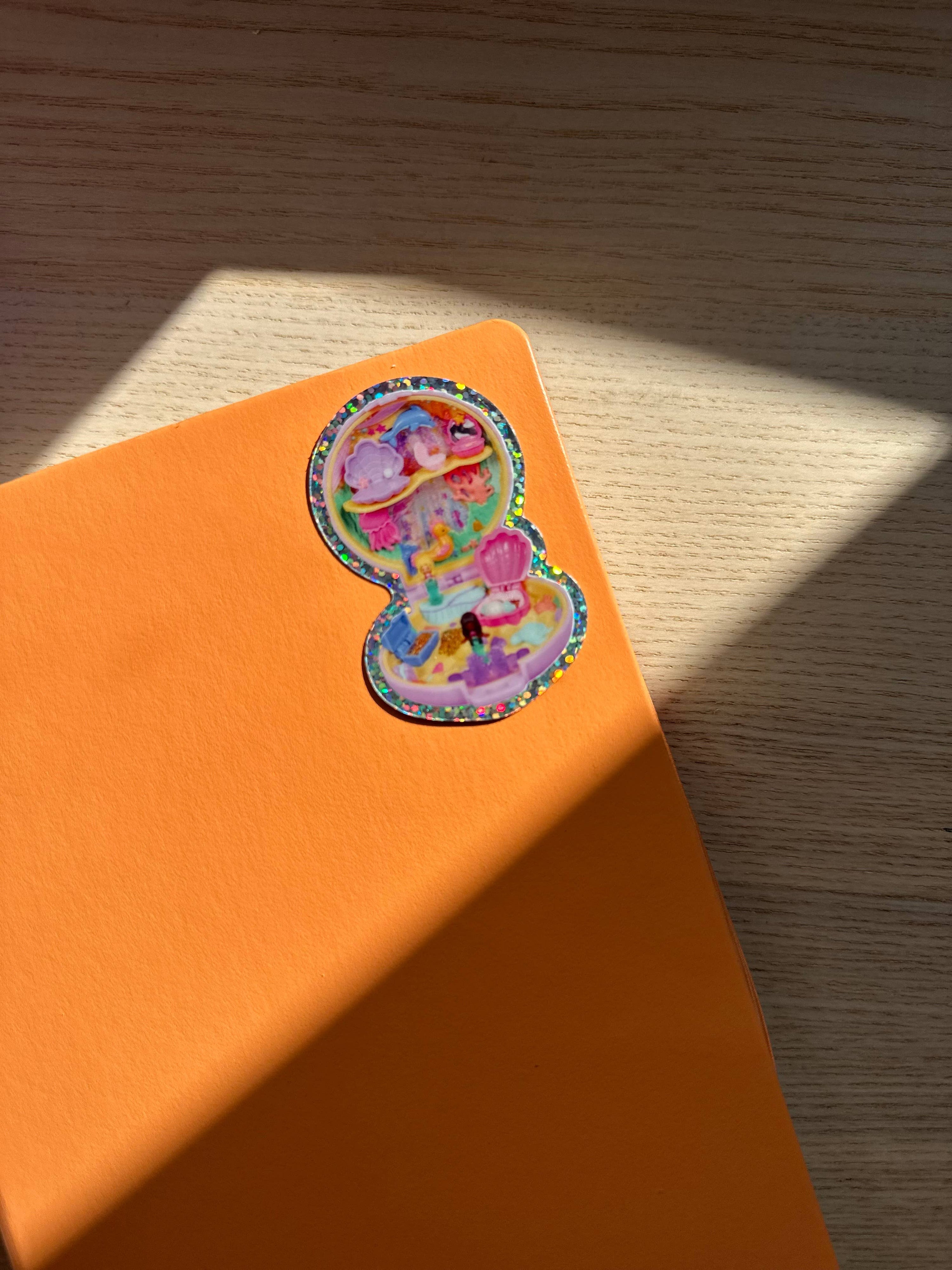 Colorful sticker on an orange notebook with a wooden surface background