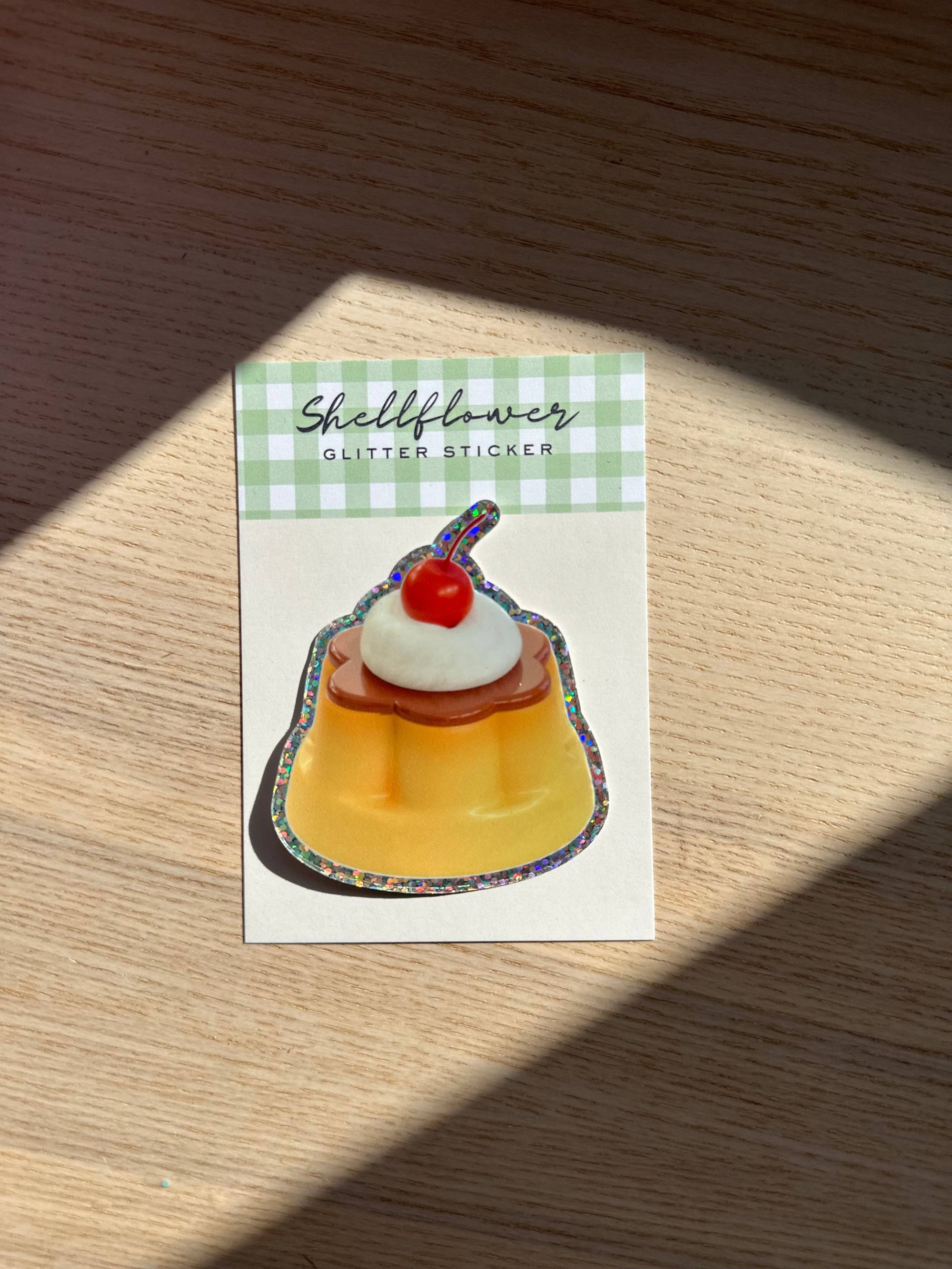 Sticker of a dessert with a cherry on top on a green checkered background