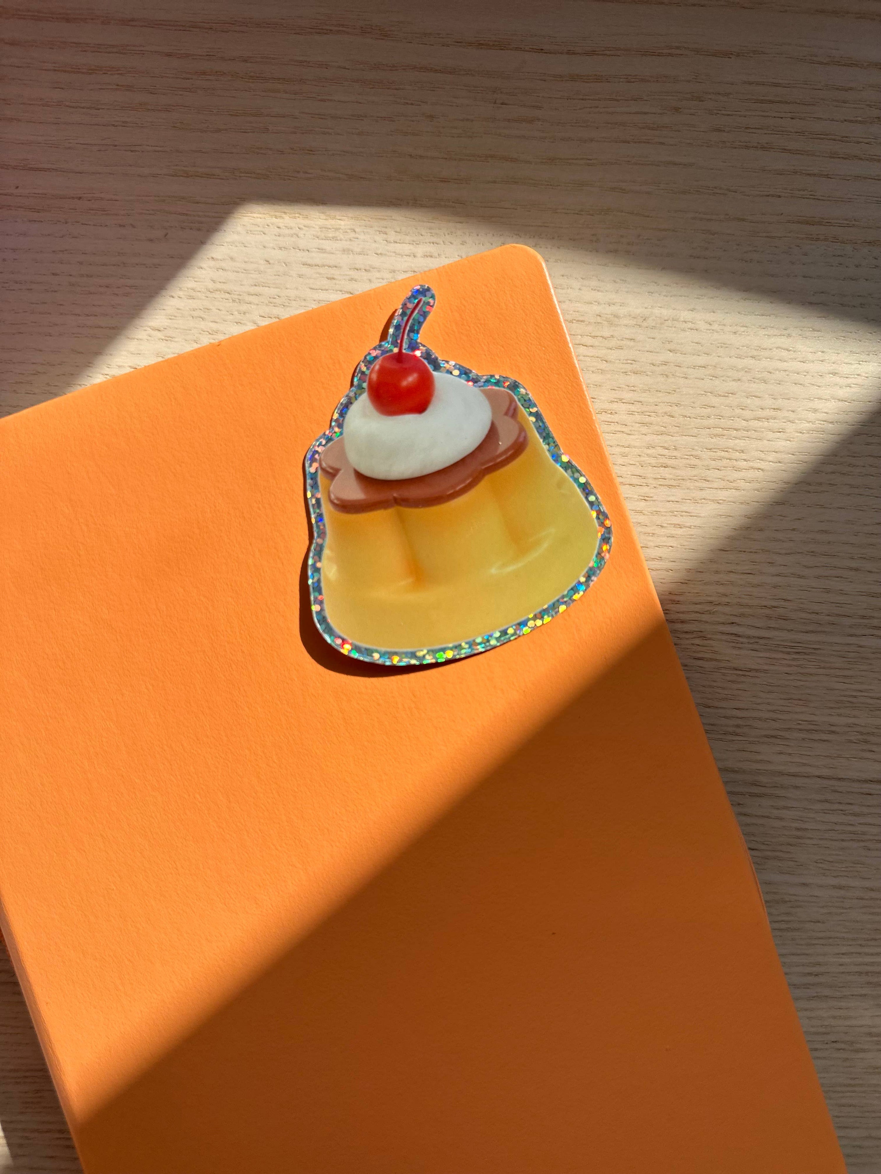 Small cake figurine on an orange box with a wooden surface background