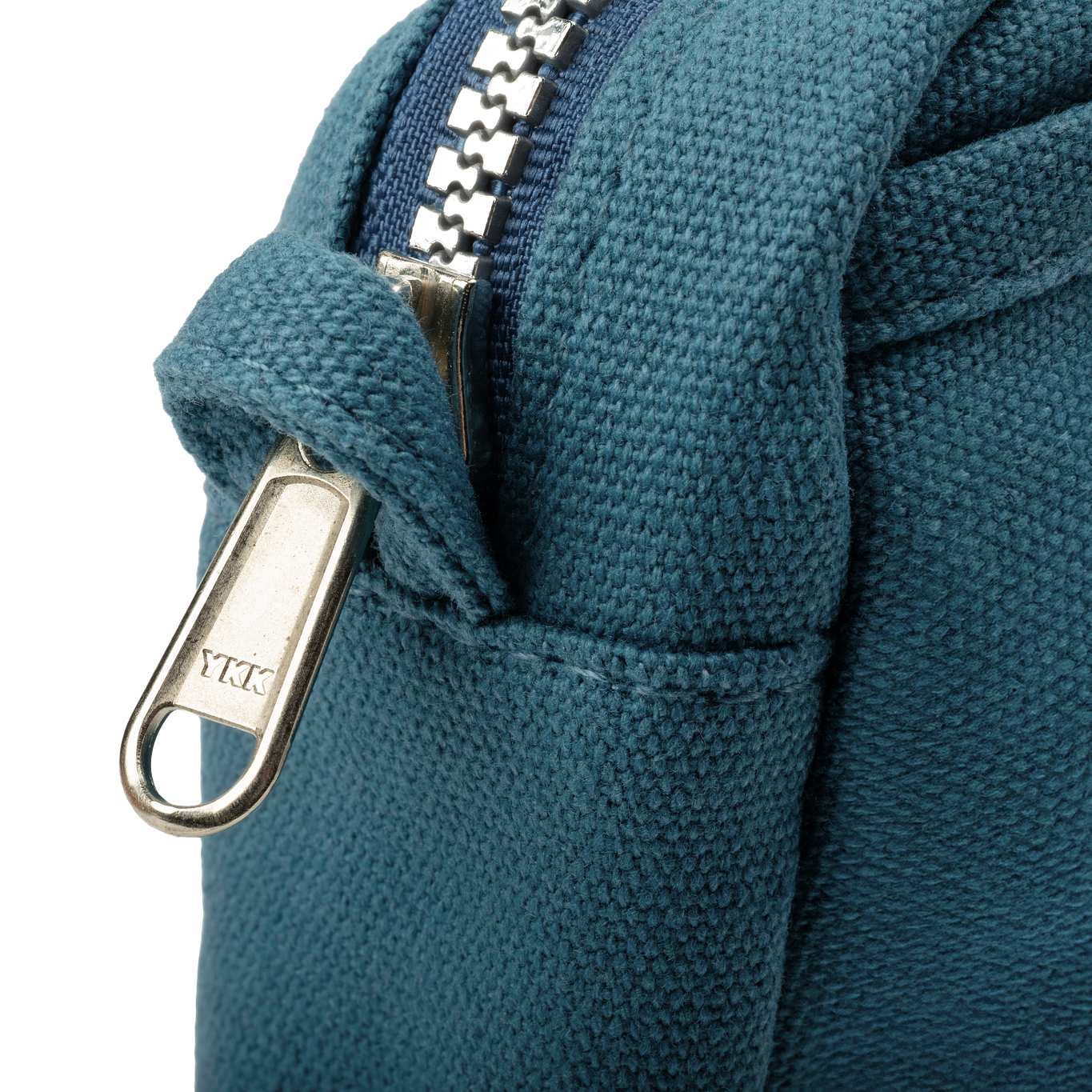 Close-up of a blue fabric bag with a metal zipper, featuring the YKK brand.
