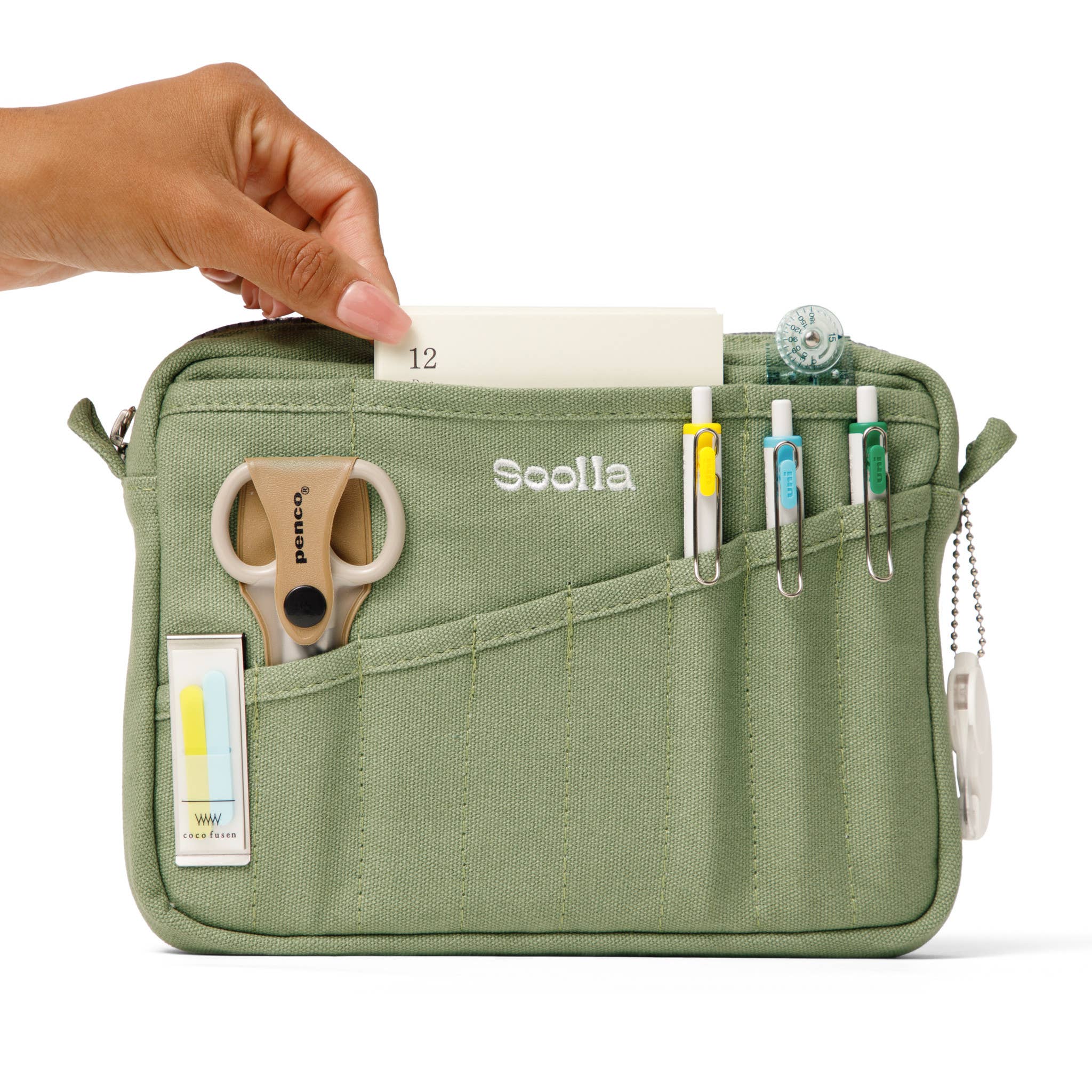 Green organizer bag with stationery items and a hand interacting with it, branded 'Soolala'.