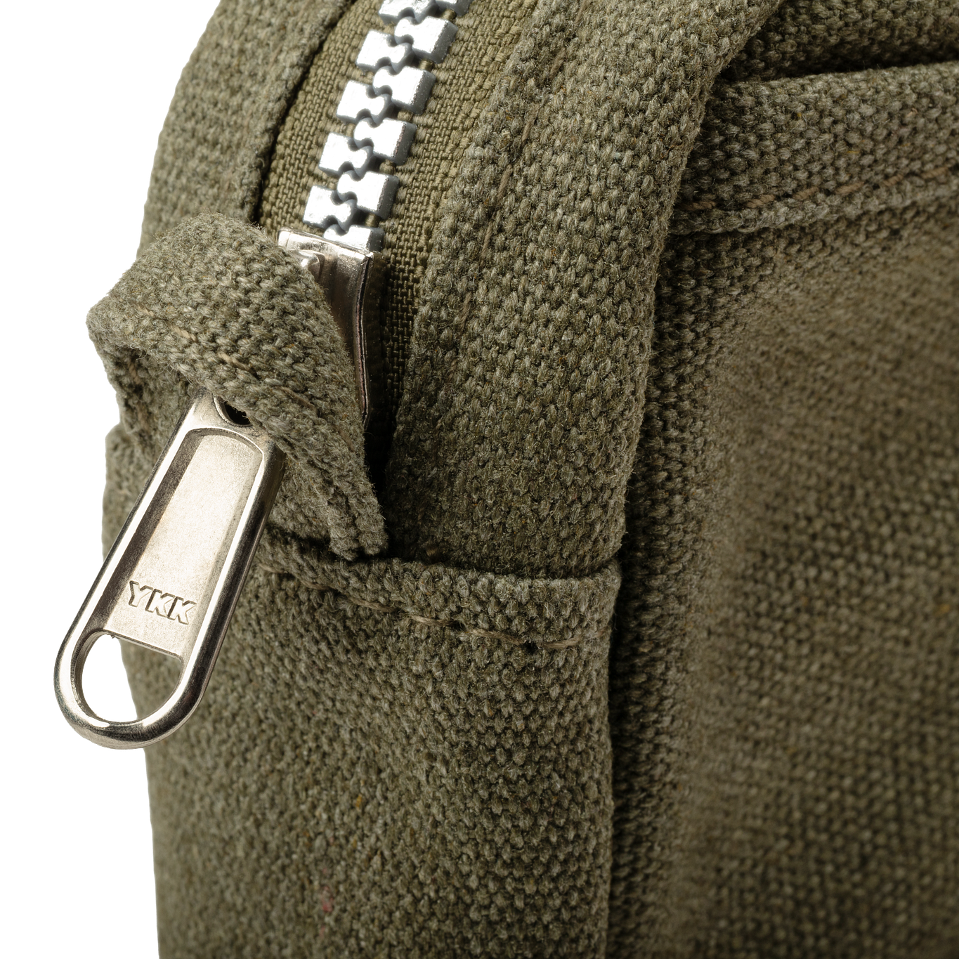 Close-up of a green backpack with a zipper and visible brand logo.