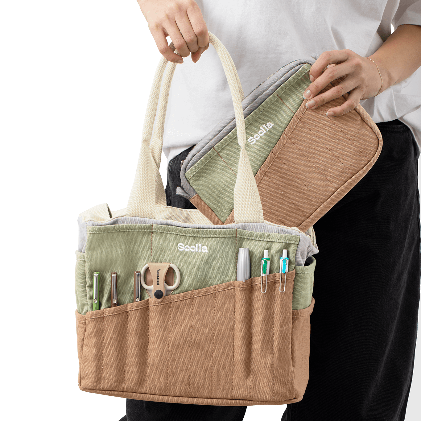 Person holding a beige and green bag with multiple compartments and tools.