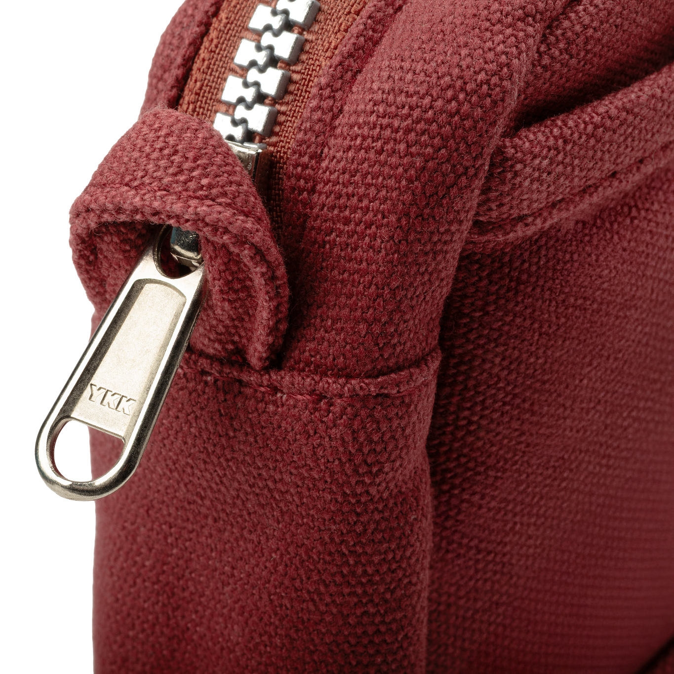 Close-up of a maroon fabric with a zipper and 'YKK' brand logo.