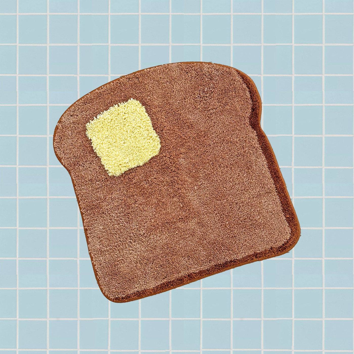 Textured brown and yellow object resembling a slice of toast on a grid background
