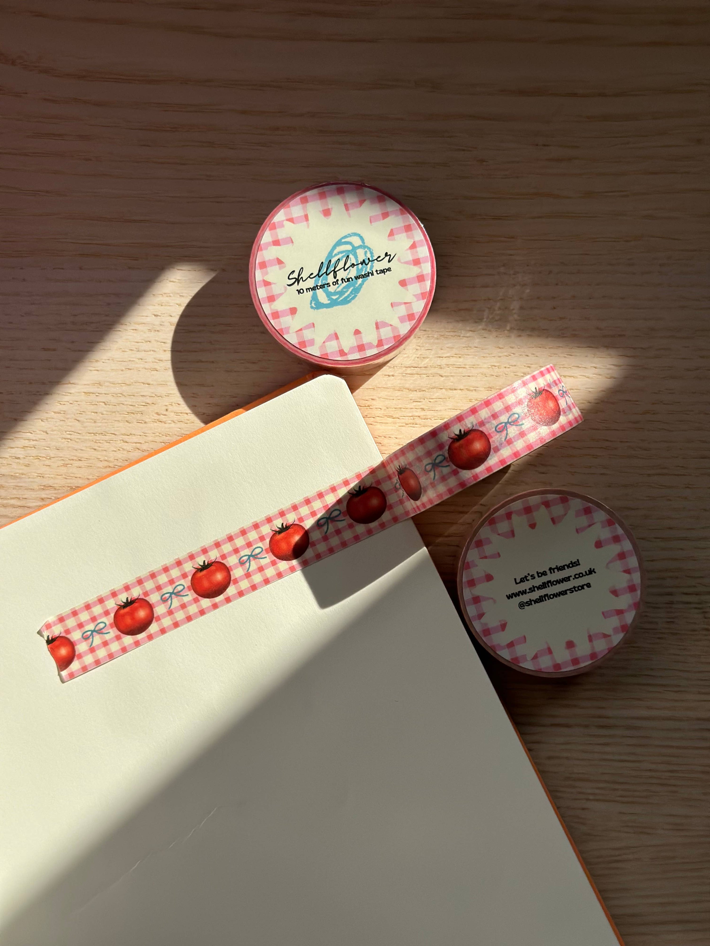 Decorative tape with red berries and a checkered pattern on a wooden surface