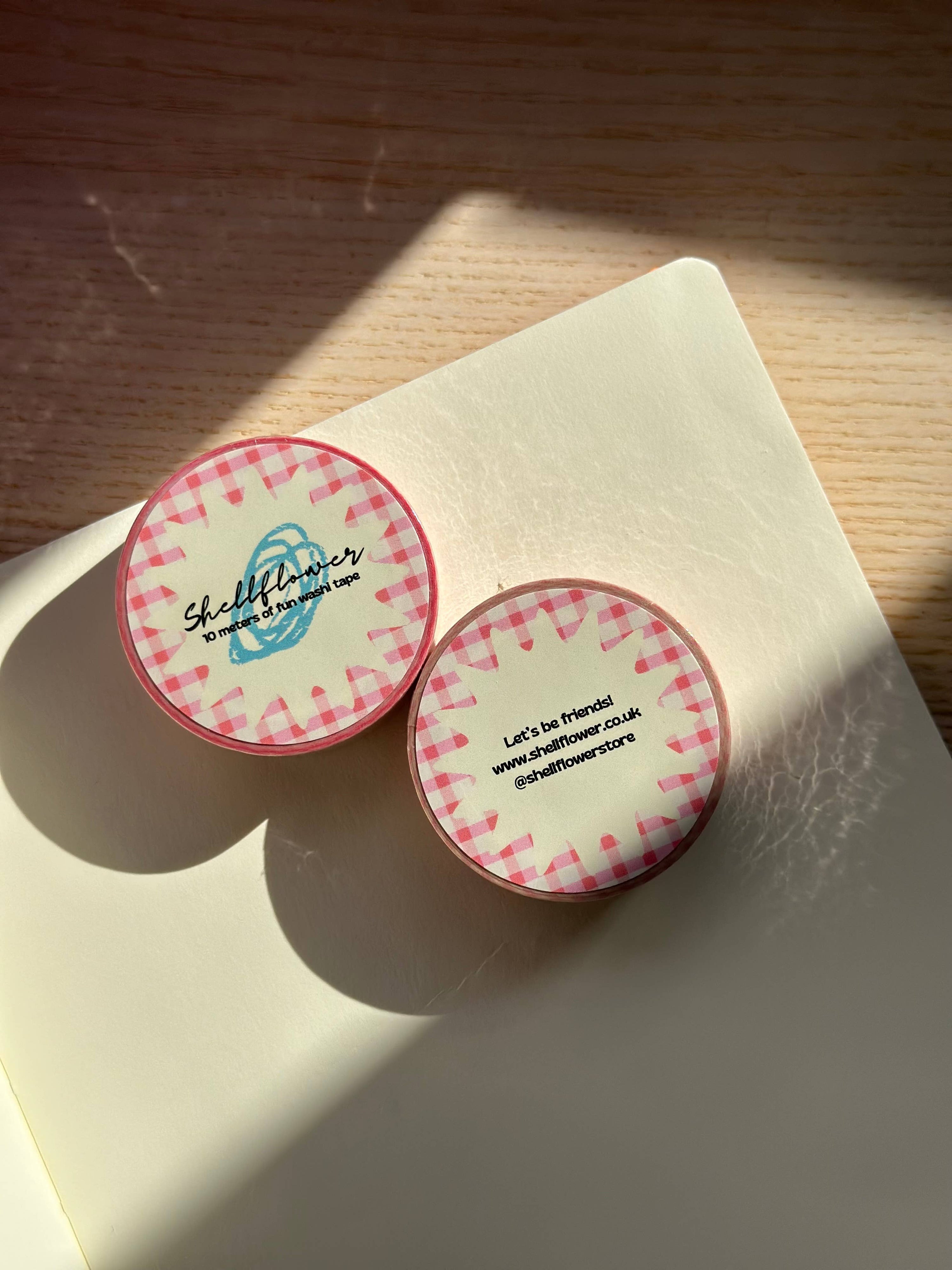 Two round stickers with checkered border and text on a light surface.