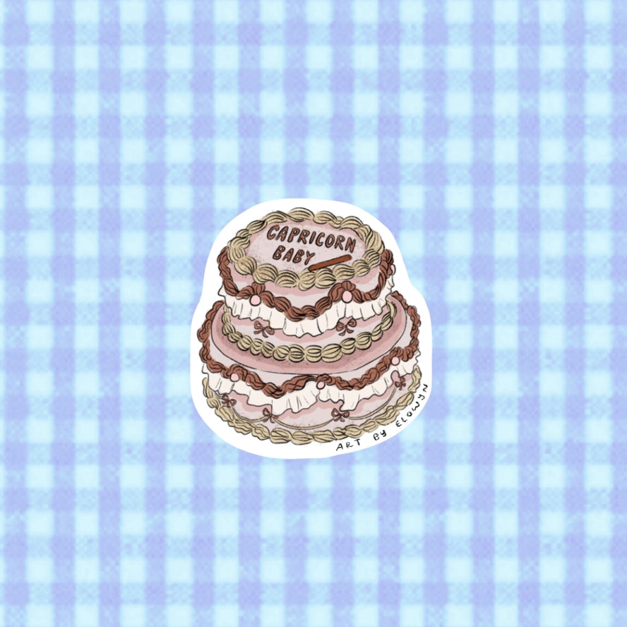 Sticker of a three-tiered cake with 'Capricorn Baby' text on a blue checkered background