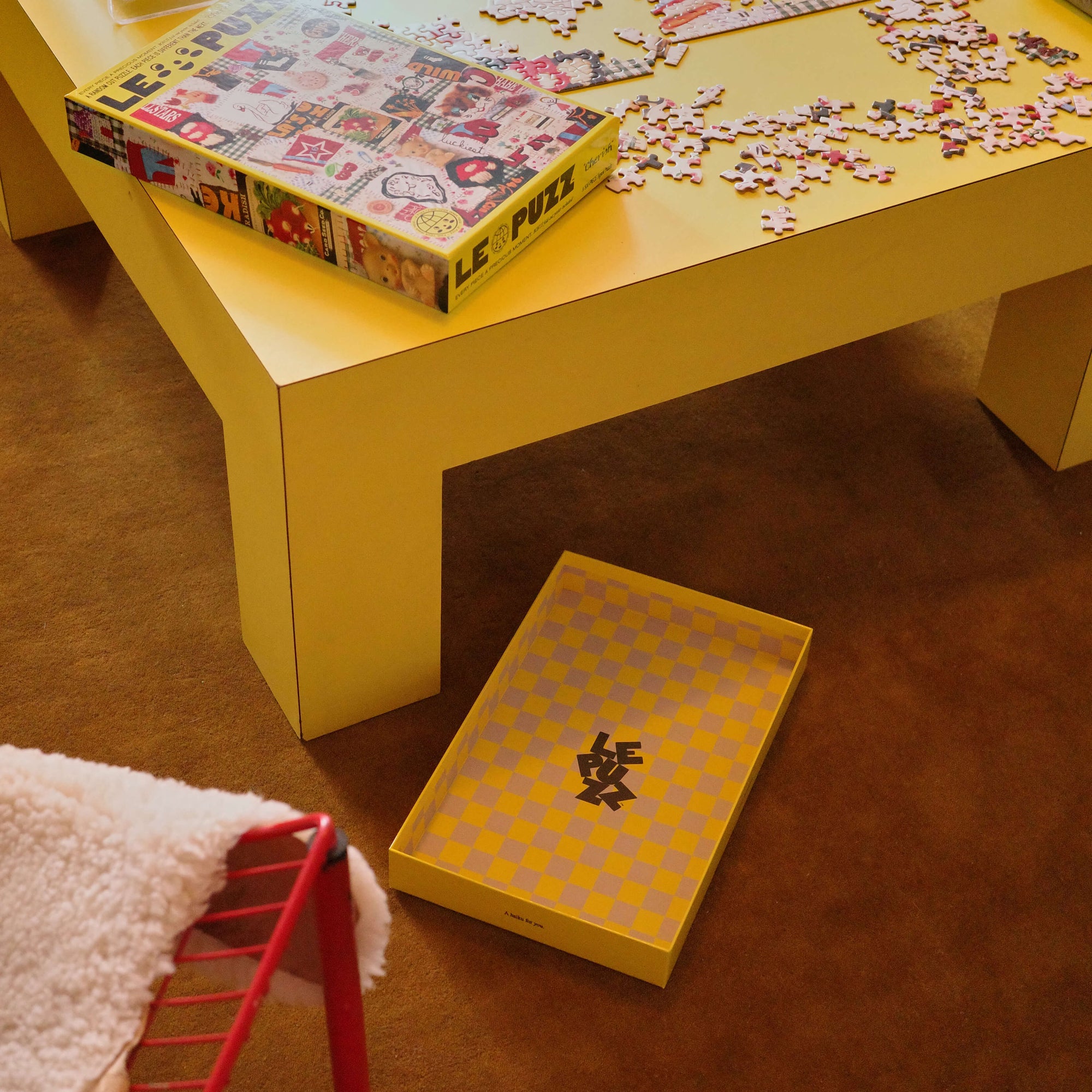 Yellow table with a puzzle and box on a brown floor
