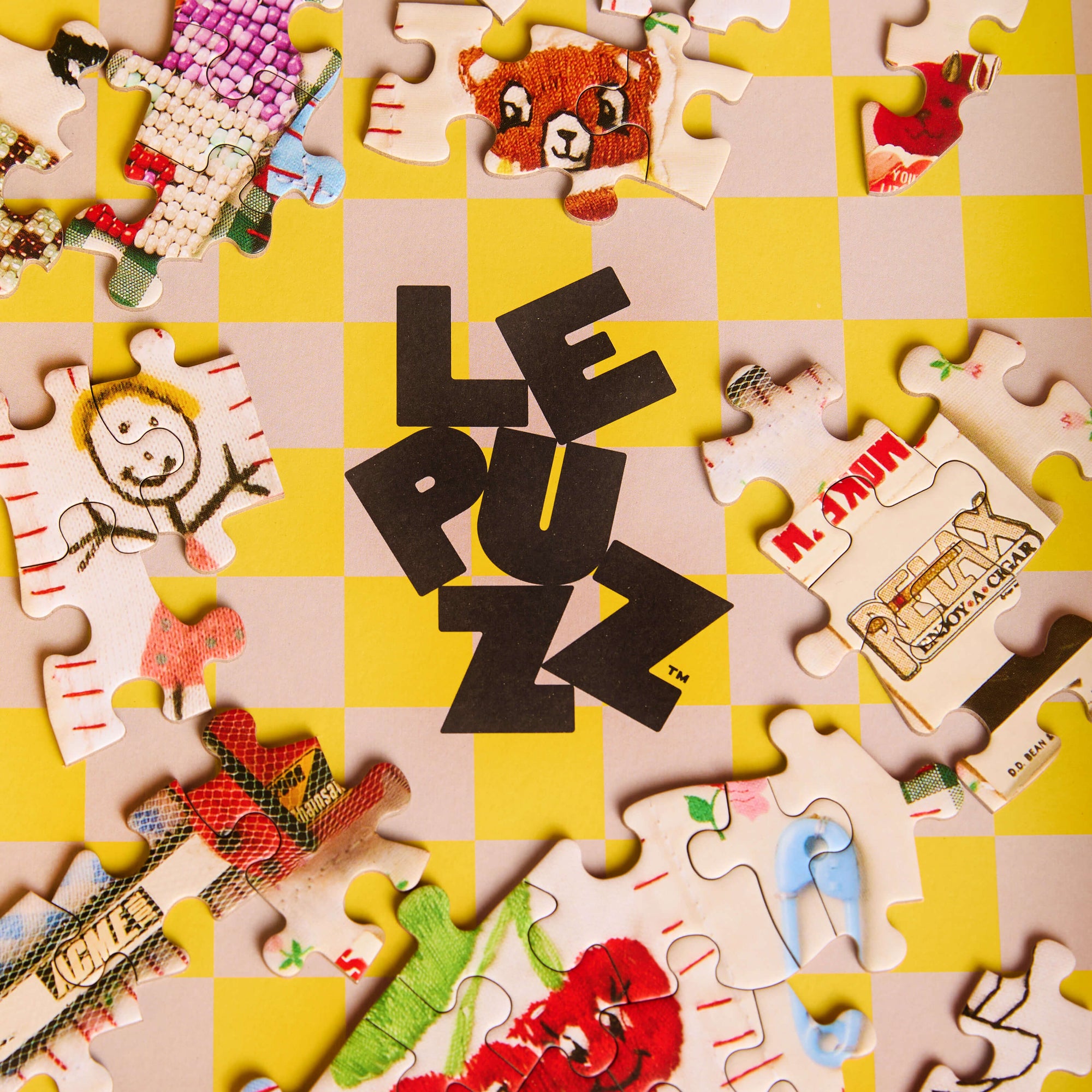 Jigsaw puzzle pieces with colorful designs on a yellow and pink checkered background, featuring the brand 'Le Puzz'.