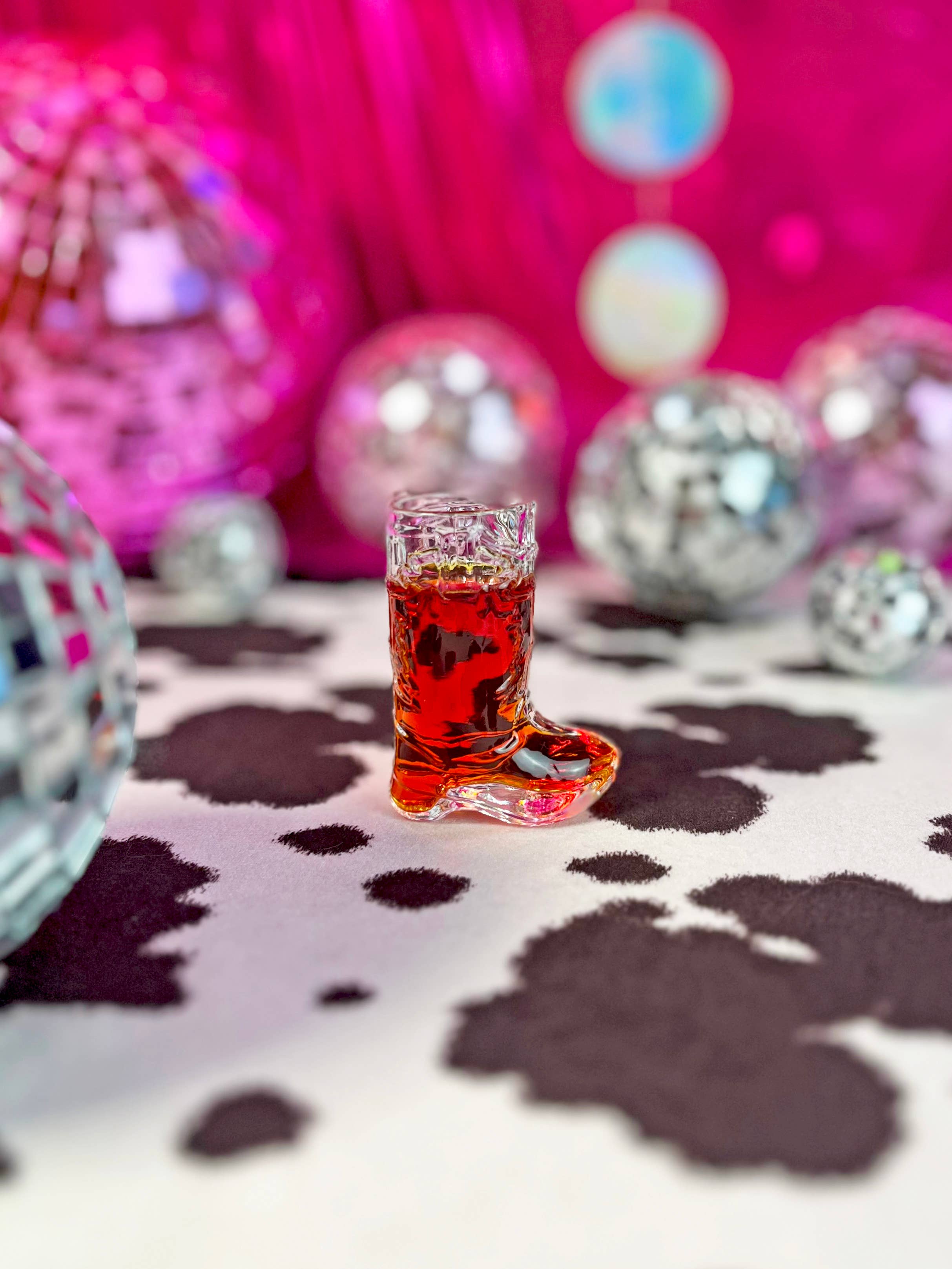 cowboy boot shot glass on cowprint with disco balls