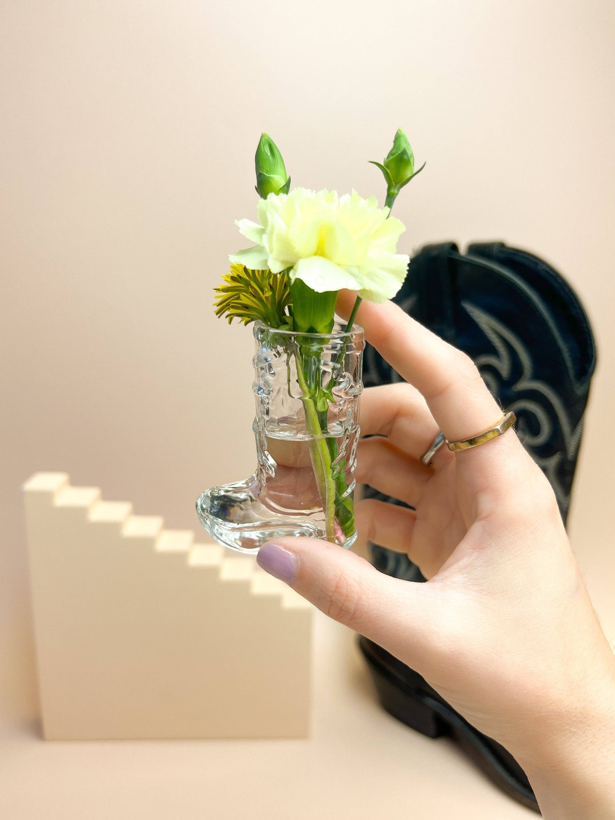 cowboy boot shot glass used as a mini vase with water