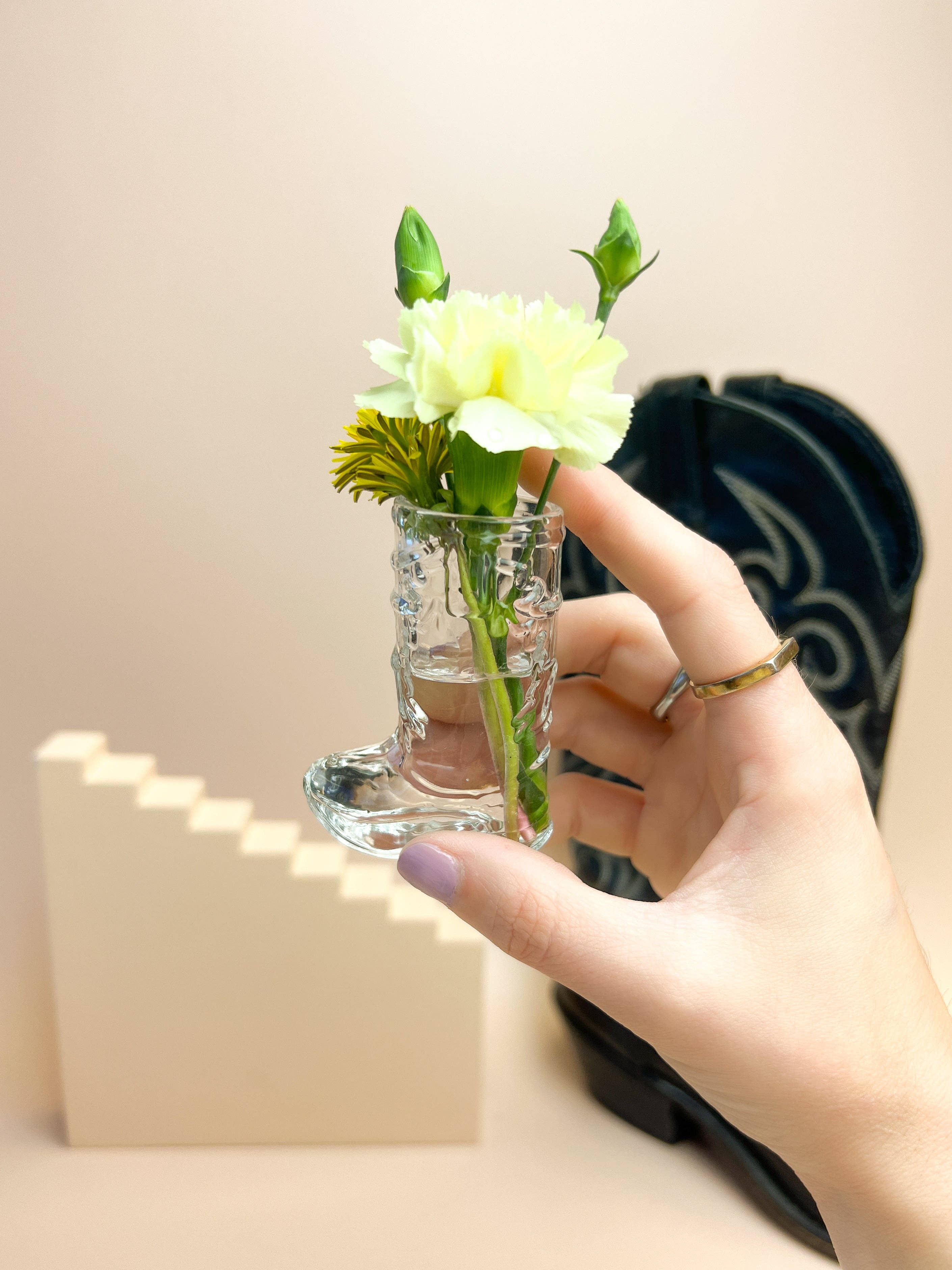 cowboy boot shot glass used as a mini vase with water